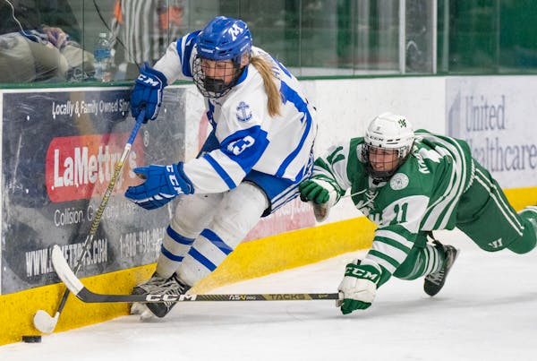 Minnetonka forward Lindzi Avar (13) carries the puck past Holy Family defender Ella Knewtson (11) during the first period of the Class 2A Section 2 gi