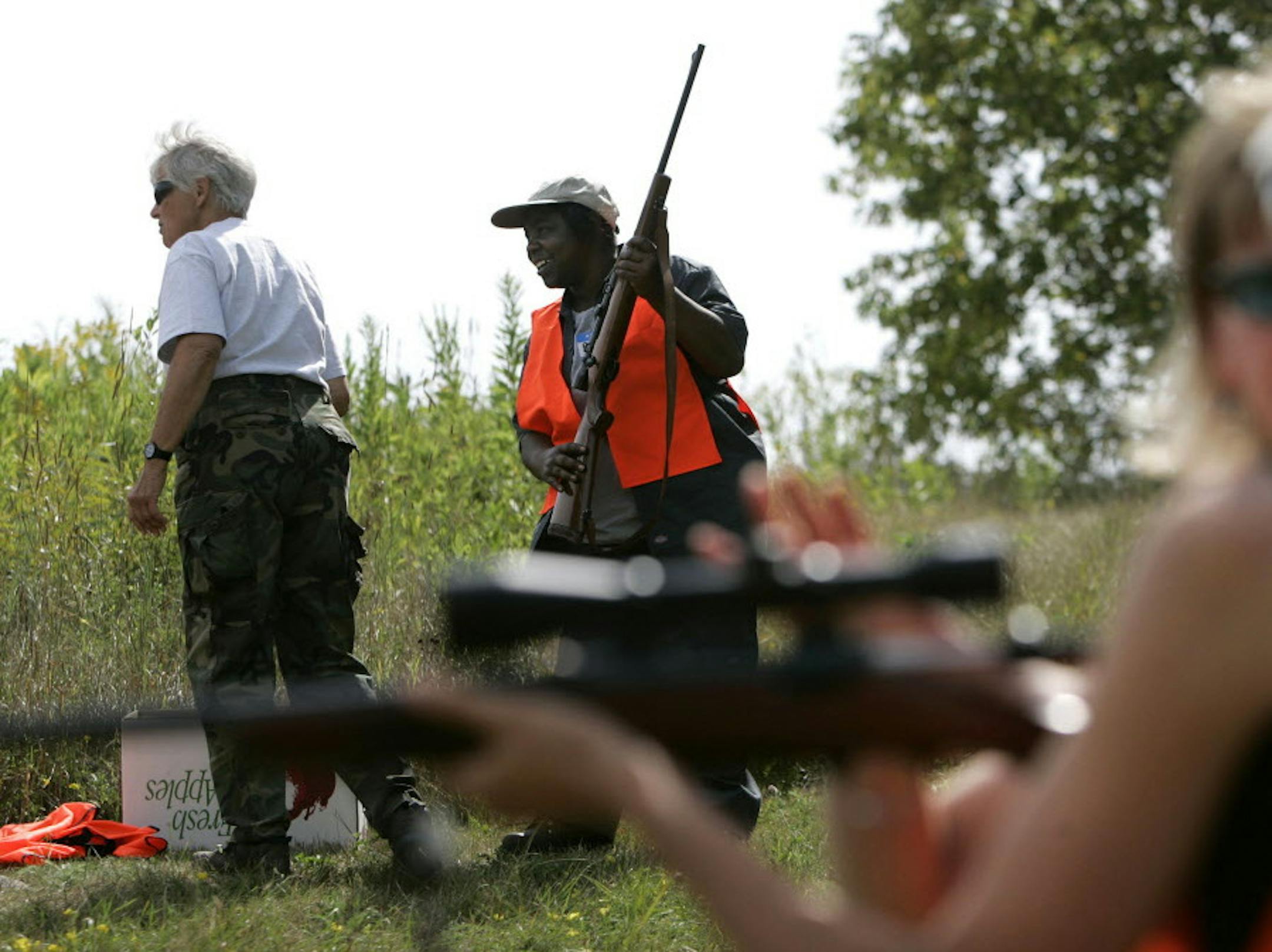 DAVID JOLES • djoles@startribune.com Mora, MN - Aug. 12, 2007 - Before testing .243 magnum rifle at a rifle range Anita Squire of Brooklyn Center hoists the gun next to instructor Betty Wilkens, left, during a Minnesota Chapter of Becoming an Outdoors Woman Program's first adult deer hunting clinic near Mora. ORG XMIT: MIN2016042613305234