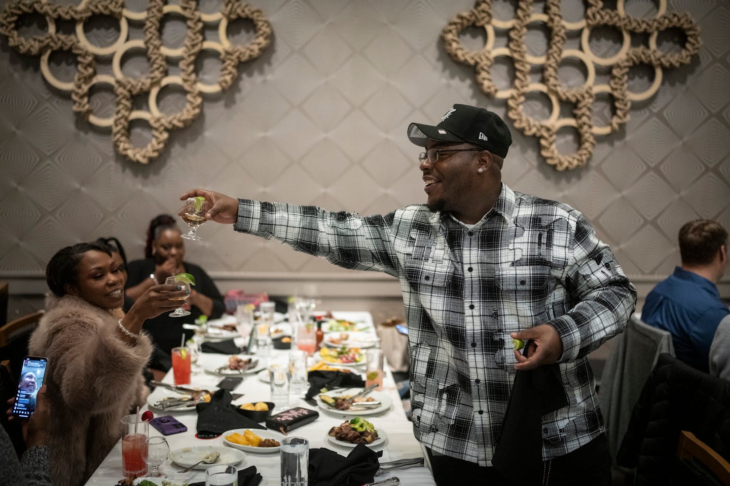 Marvin Haynes hands out tequila shots during a toast for his birthday as he hosts his family, former lawyers and friends  for a meal at Fogo de Chao in Minneapolis, Minn. on Friday, December 6, 2024. A year ago on his birthday Haynes found out he was going to be released from prison. 