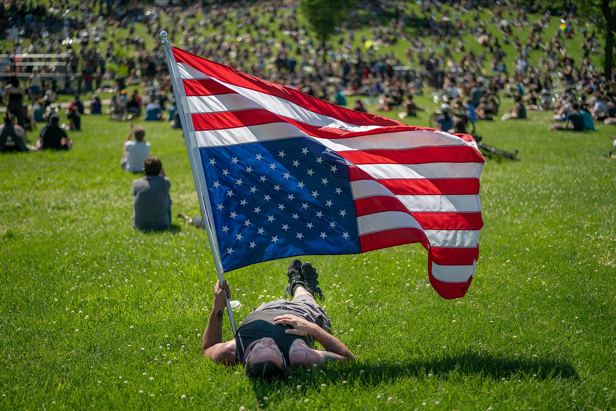 Rory Wakemup held a U.S. flag at the "The Path Forward" meeting at Powderhorn Park on Sunday, June 7.
