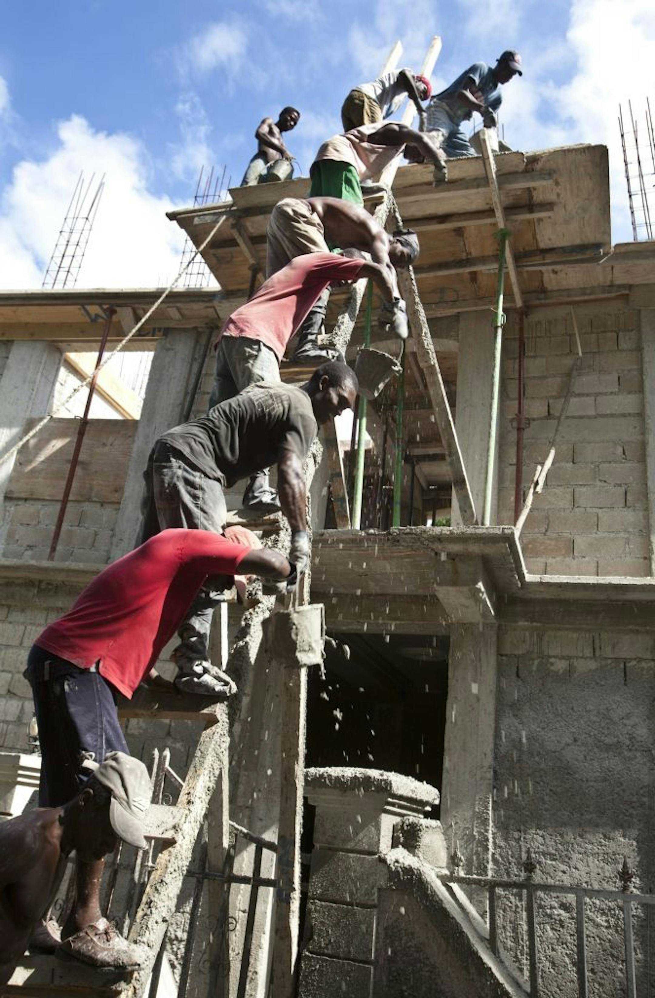 Workers form a chain to haul cement buckets to the upper levels in the reconstruction of a hotel in Leogane in December 2010. Leogane, the town at the epicentre of the earthquake, continues to try and dig itself from the rubble.