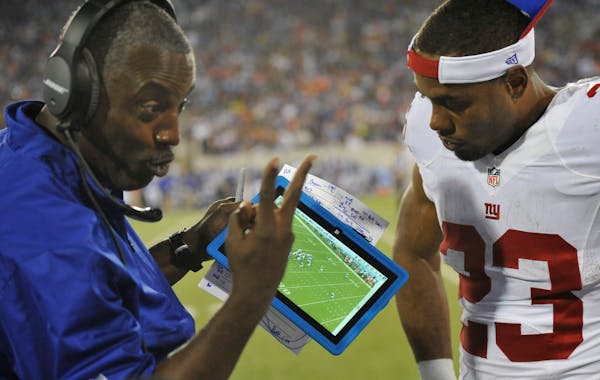 New York Giants running backs coach Craig Johnson, left, uses a Microsoft Surface tablet beside running back Rashad Jennings in 2014.