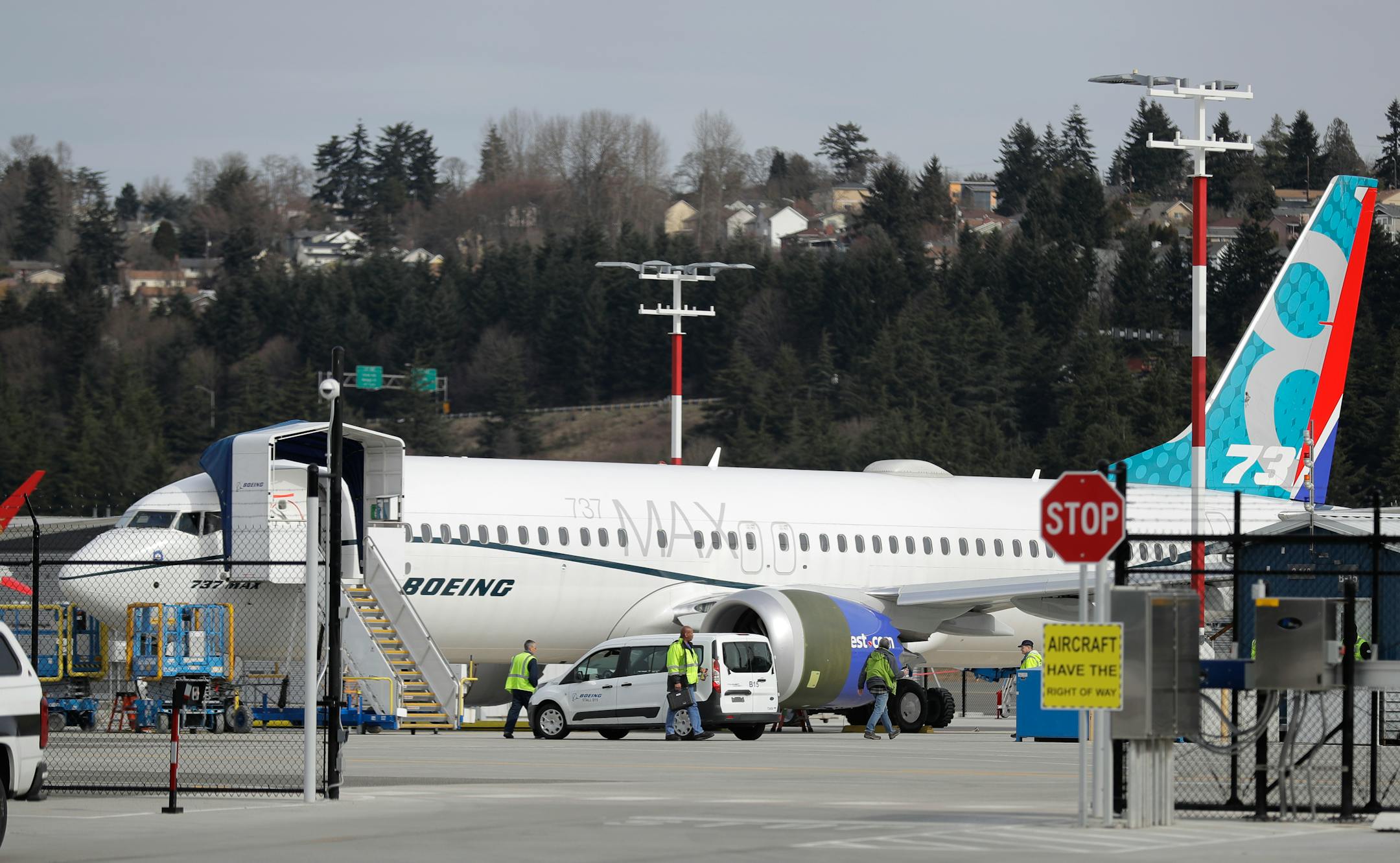Workers walk next to a Boeing 737 MAX 8 airplane parked at Boeing Field, Thursday, March 14, 2019, in Seattle. The fatal crash Sunday of a 737 MAX 8 operated by Ethiopian Airlines was the second fatal flight for a Boeing 737 Max 8 in less than six months, and more than 40 countries, including the U.S., have now grounded the planes or refused to let them into their airspace. (AP Photo/Ted S. Warren)