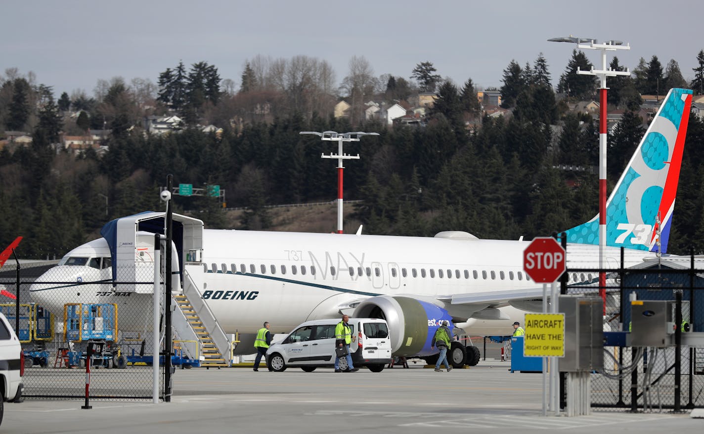 Workers walk next to a Boeing 737 MAX 8 airplane parked at Boeing Field, Thursday, March 14, 2019, in Seattle. The fatal crash Sunday of a 737 MAX 8 operated by Ethiopian Airlines was the second fatal flight for a Boeing 737 Max 8 in less than six months, and more than 40 countries, including the U.S., have now grounded the planes or refused to let them into their airspace. (AP Photo/Ted S. Warren)