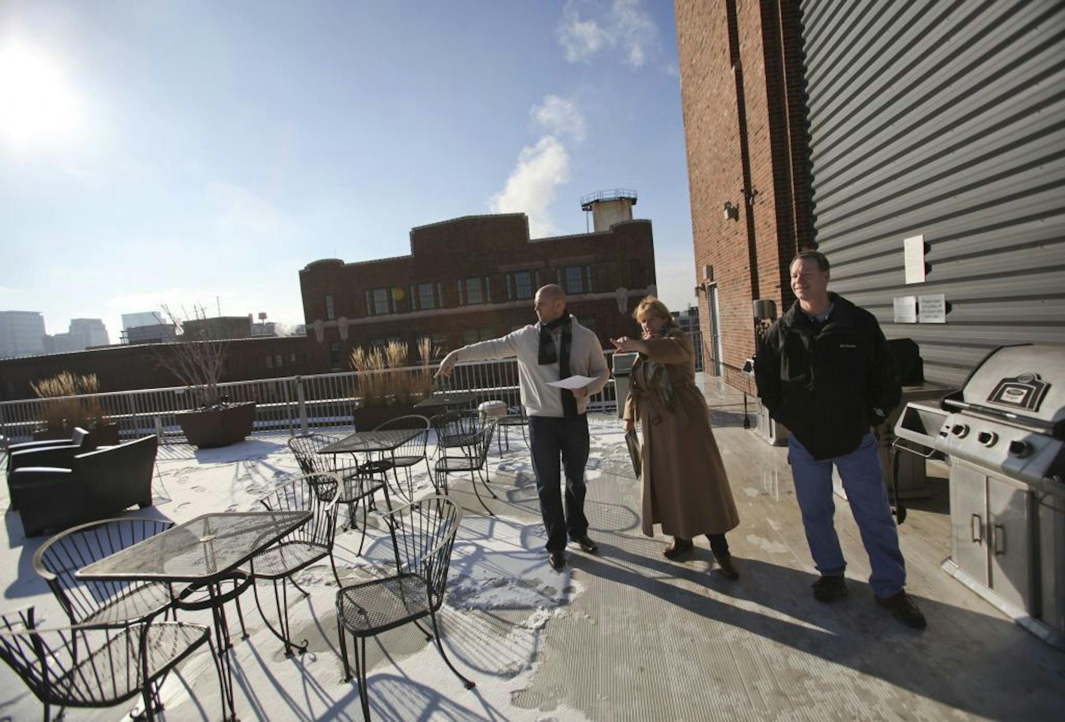 Urban real estate broker Joe Grunnet offered a tour of historic downtown neighborhoods and condos renovated from historic warehouse buildings Saturday, Dec. 8, 2012, in Minneapolis, MN. Here, Grunnet, left, showed a condo rooftop patio at Tower Lofts to Ed and Laurie Harkness of Chanhassen. The building once housed a burlap bag factory and later artists lofts.