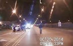 In this Oct. 20, 2014 frame from dash-cam video provided by the Chicago Police Department, Laquan McDonald, right, walks down the street moments befor