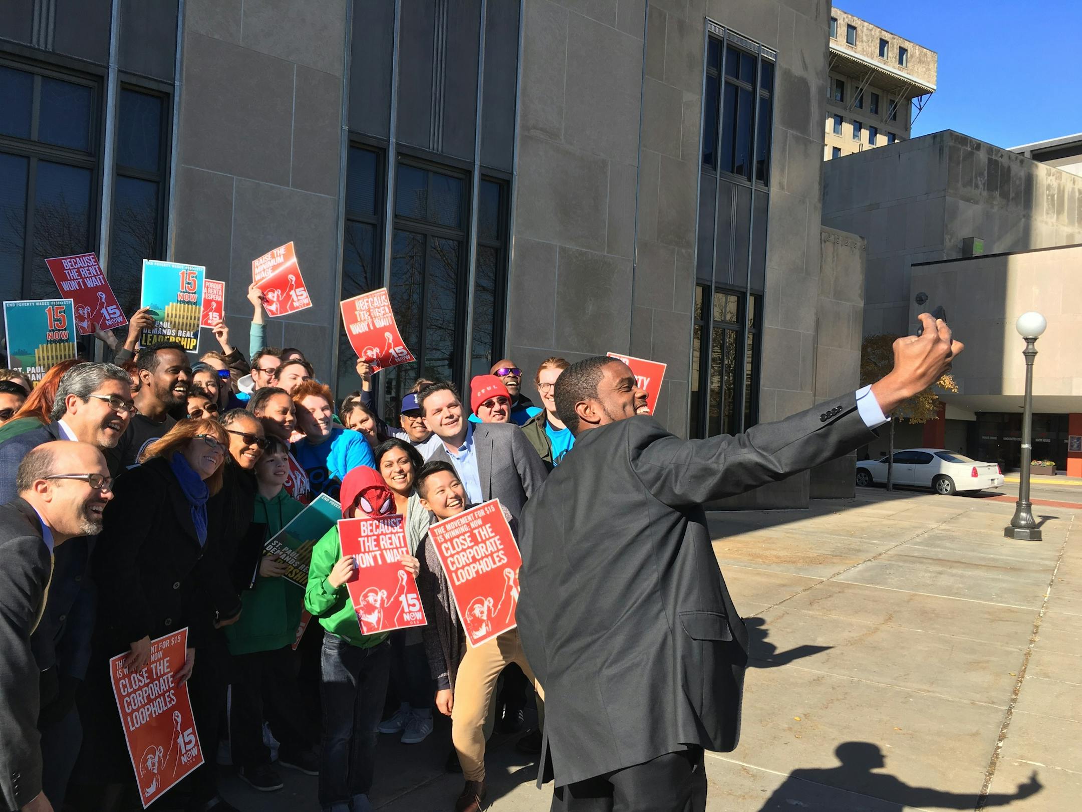 St. Paul Mayor Melvin Carter poses for a selfie in front of demonstrators for a $15 minimum wage.