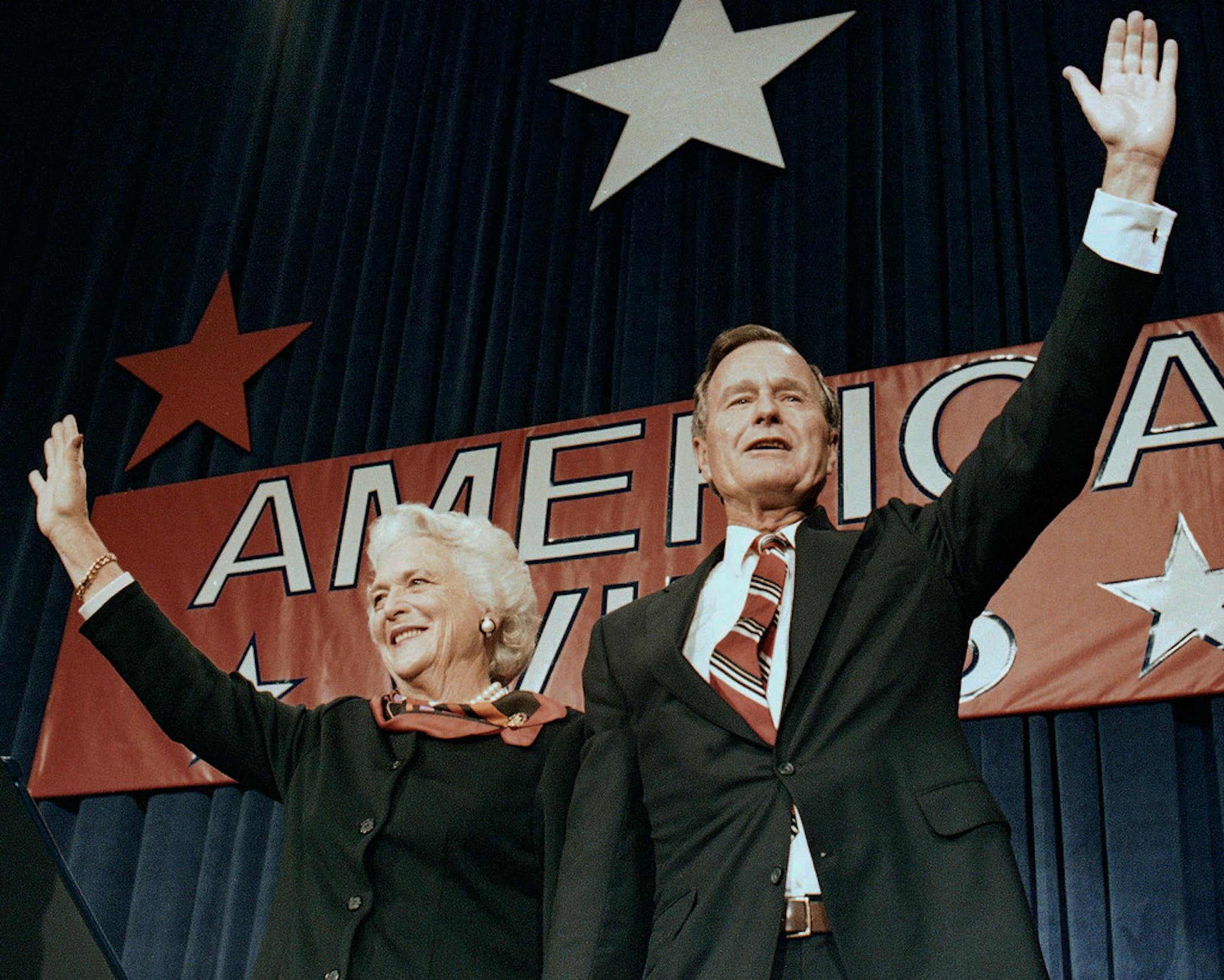 FILE - In this Nov. 8, 1988 file photo, President-elect George H.W. Bush and his wife Barbara wave to supporters in Houston, Texas after winning the presidential election.
