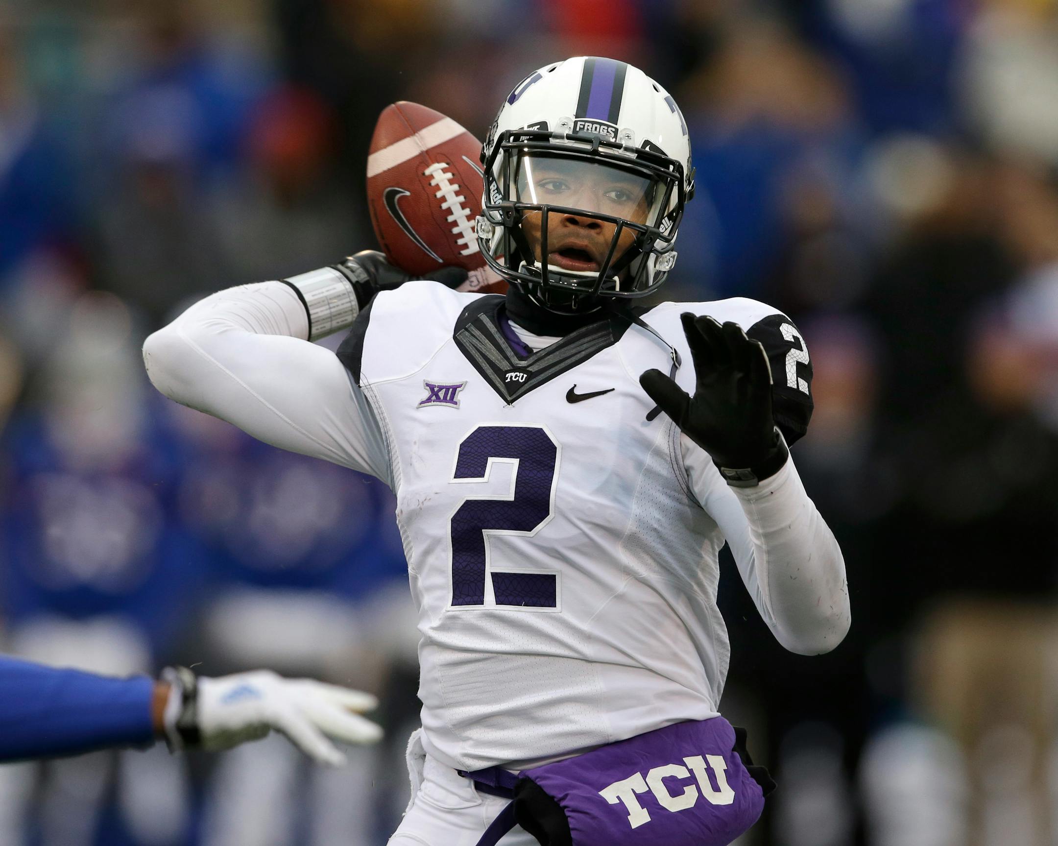 FILE - In this Nov. 15, 2014, file photo, TCU quarterback Trevone Boykin (2) passes to a teammate during the first half of an NCAA college football game against Kansas in Lawrence, Kan. Boykin, the only TCU player ever with a 200-yard passing game, 100-yard receiving game and 100-yard rushing game in the same season is now focused only on being the quarterback in TCU's new up-tempo offense, with the No. 5 Horned Frogs in playoff contention and him in the Heisman conversation. (AP Photo/Orlin Wag