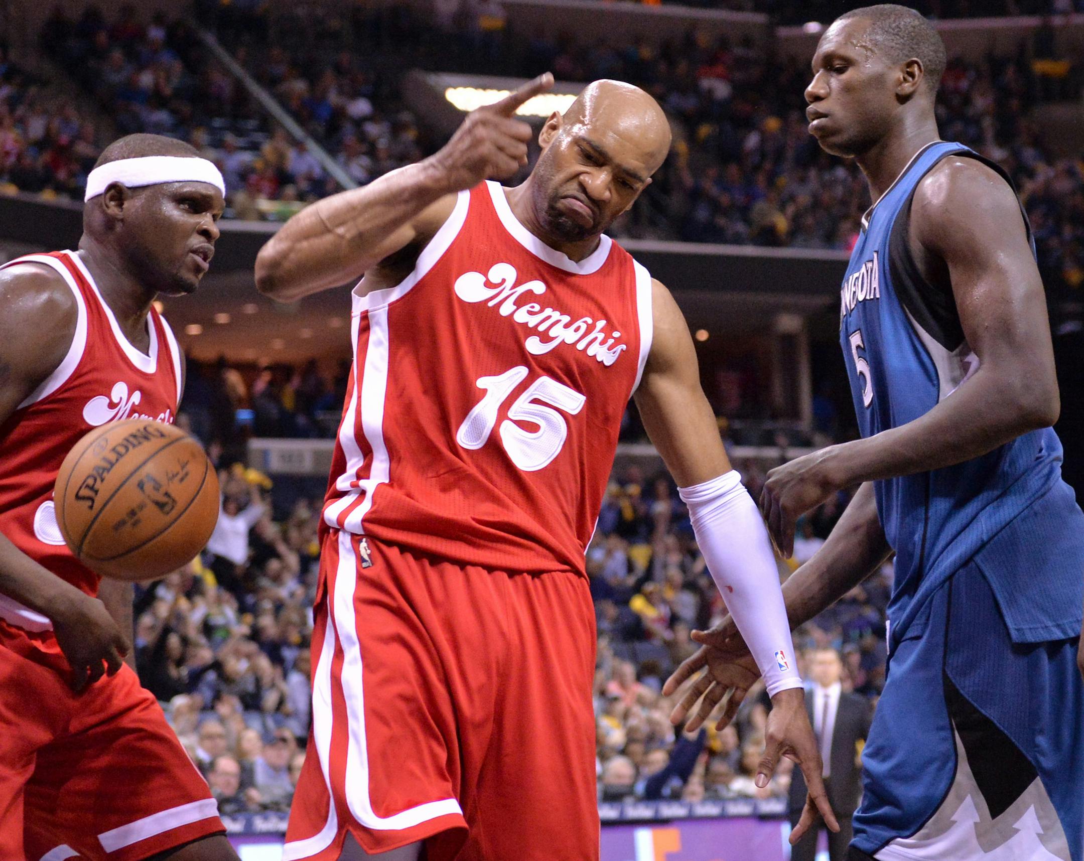Memphis Grizzlies guard Vince Carter (15) reacts between Grizzlies forward Zach Randolph, left, and Minnesota Timberwolves center Gorgui Dieng (5) after scoring in the second half of an NBA basketball game Friday, Feb. 19, 2016, in Memphis, Tenn. (AP Photo/Brandon Dill)