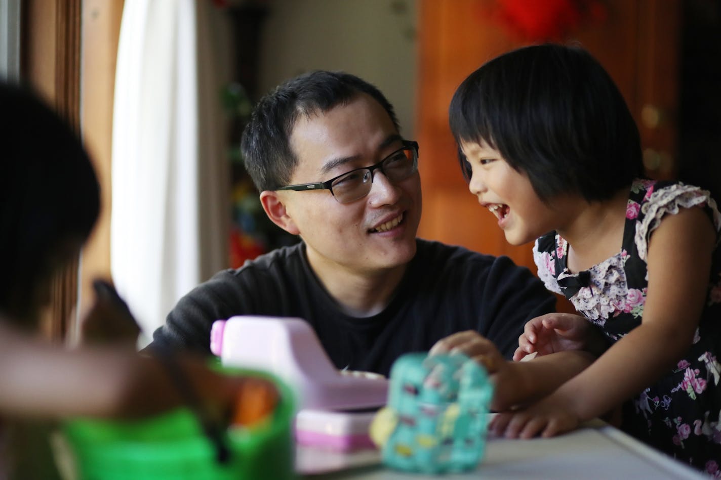 U biophysics graduate Ji Li has landed on a backlog for mainland Chinese natives to get a green card. He's waited for two years and likely has another two to go. Here plays with his daughter Manda, 4, after work.