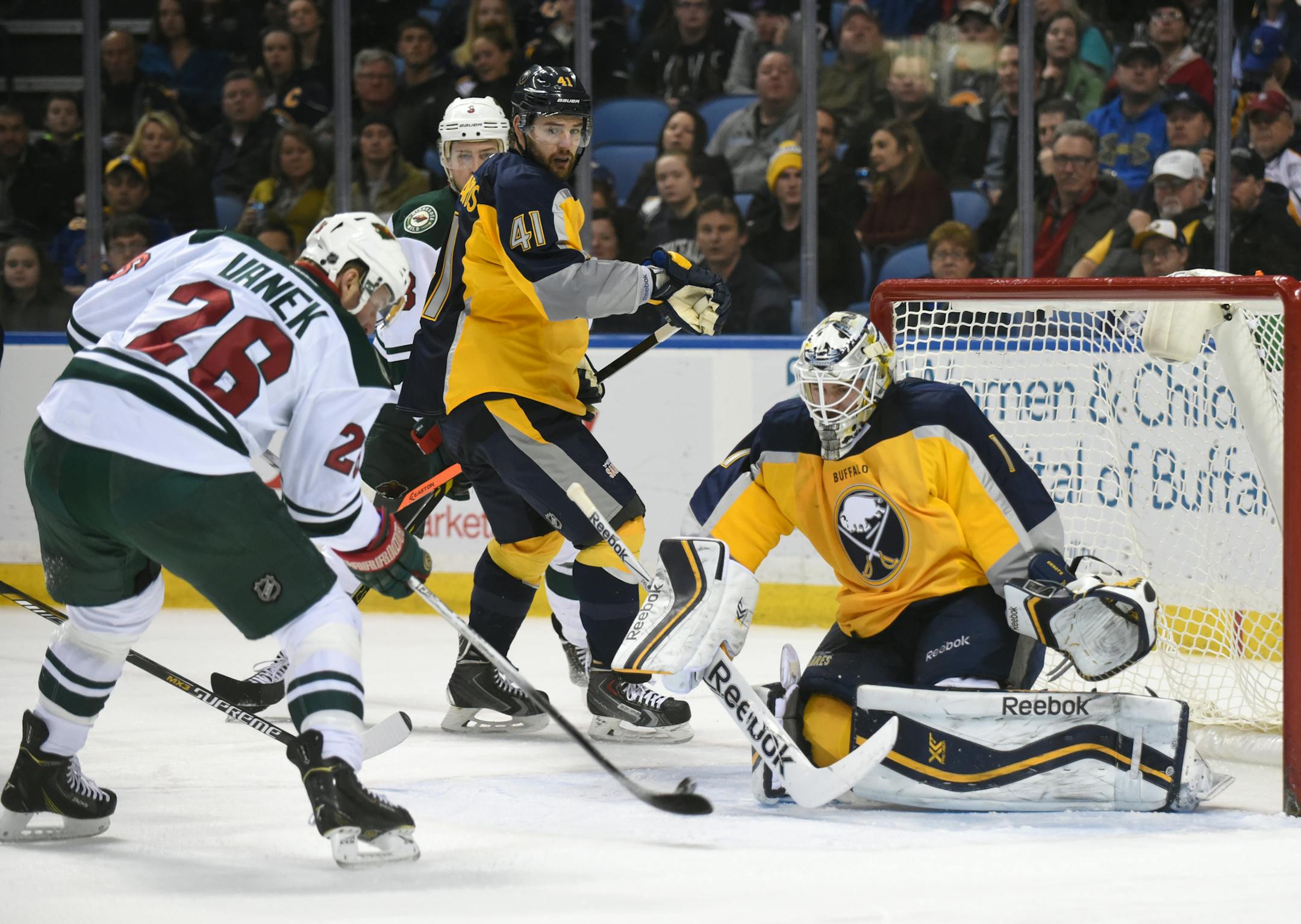 Minnesota Wild left winger Thomas Vanek (26), of Austria, shoots the puck against Buffalo Sabres goaltender Jhonas Enroth (1), of Sweden, as Sabres defenseman Andrej Meszaros (41), of Slovakia, looks on during the second period of an NHL hockey game Thursday, Jan. 15, 2015, in Buffalo, N.Y. Minnesota won 7-0. (AP Photo/Gary Wiepert)