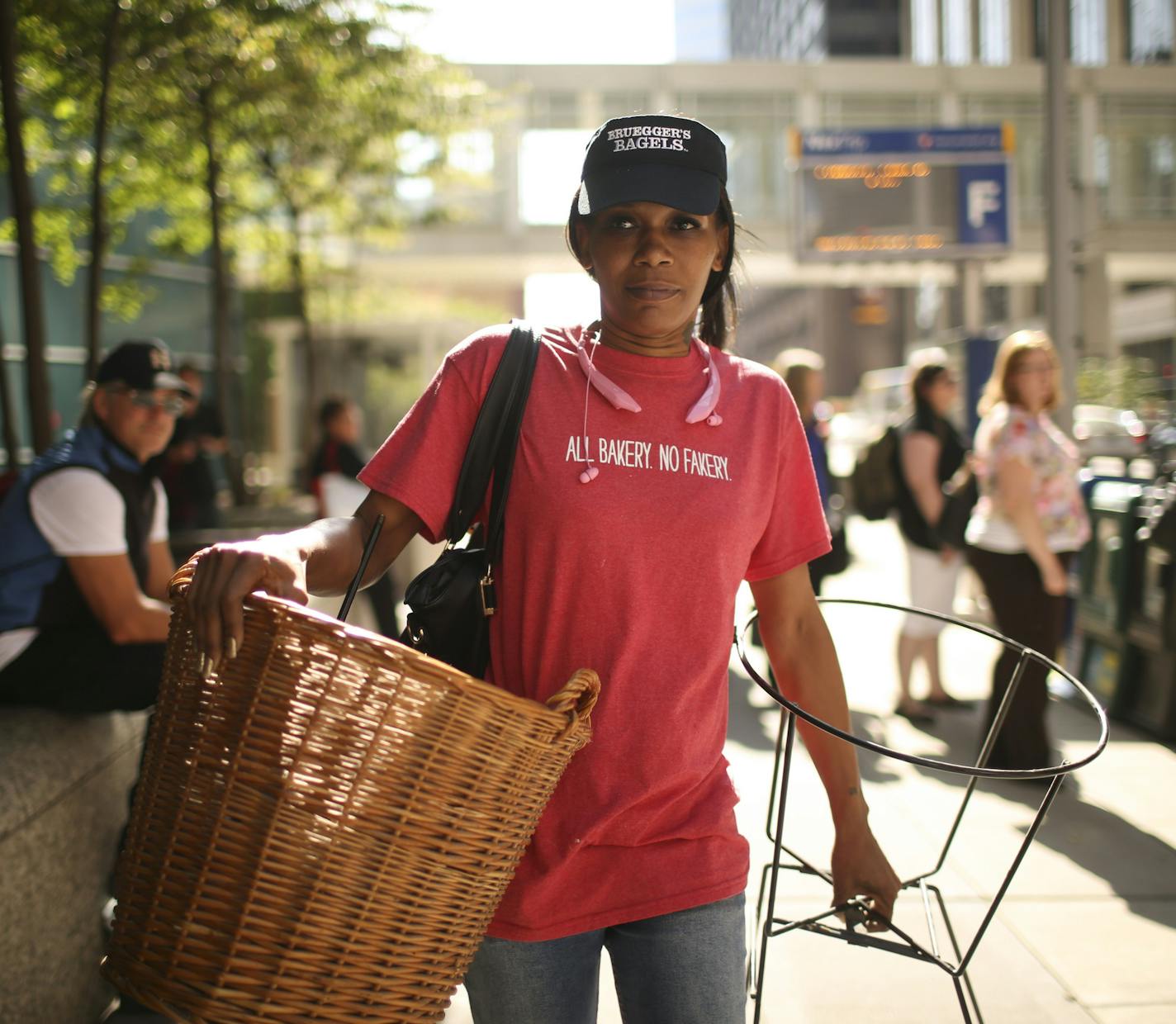 Living on less: Tiffony Henderson walked to the bus after work Tuesday in downtown Minneapolis. She had a stand and wicker basket discarded at work that she thought would make a great plant holder at home.