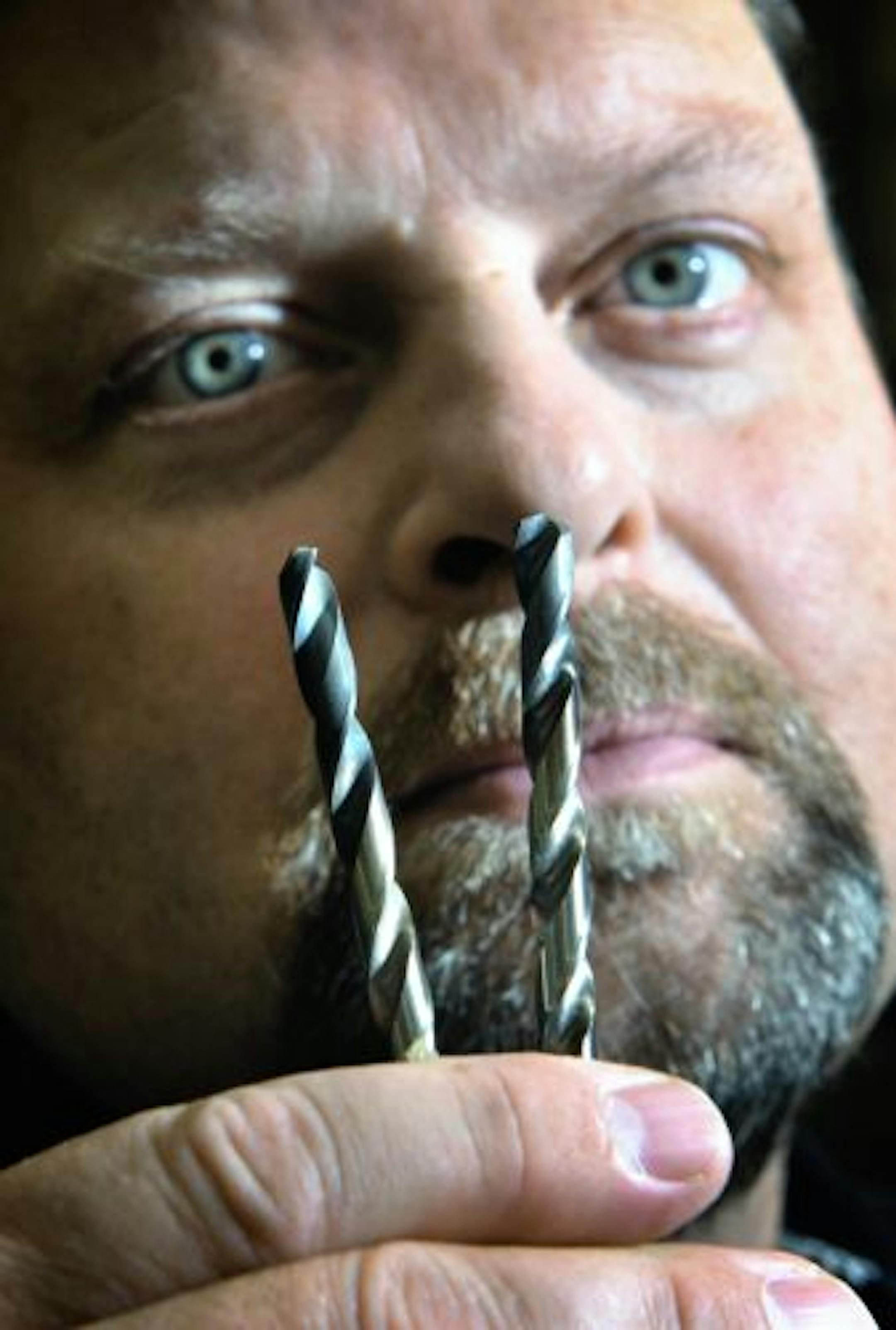 Daniel Fox, presdent and CEO of Rushford Hypersonic, holds two drill bits coated with his nano particles, giving them incredible strength.