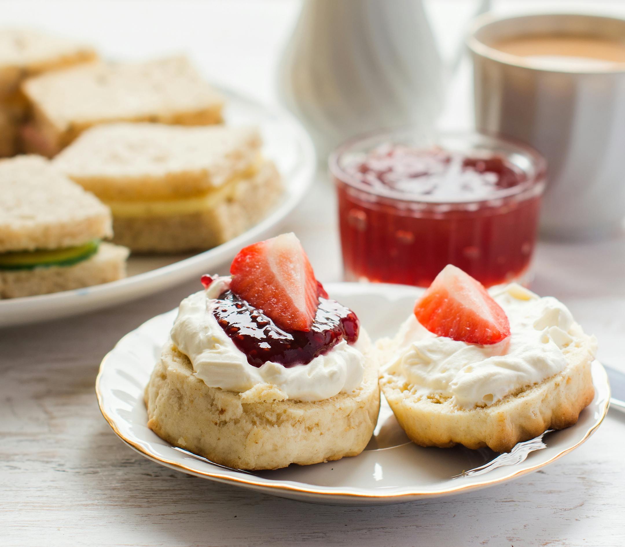 Traditional English afternoon tea: scones with clotted cream and jam, strawberries, with various sadwiches. istock