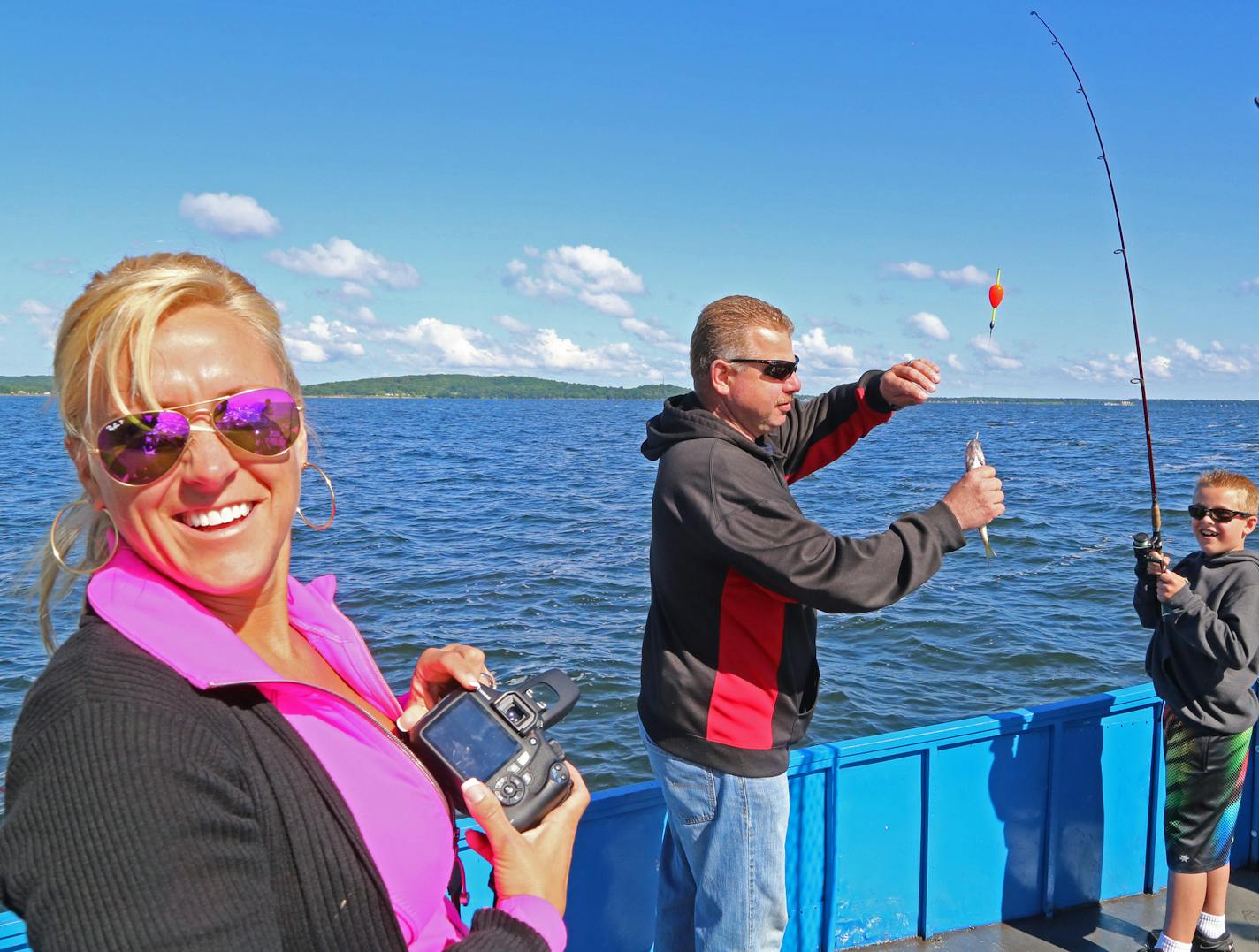 Kristi Collins, left, her husband Phil Collins and their son Gavin, 8, of Elk River, are all smiles after Gavin reeled in a walleye last week while fishing from a Mille Lacs launch.