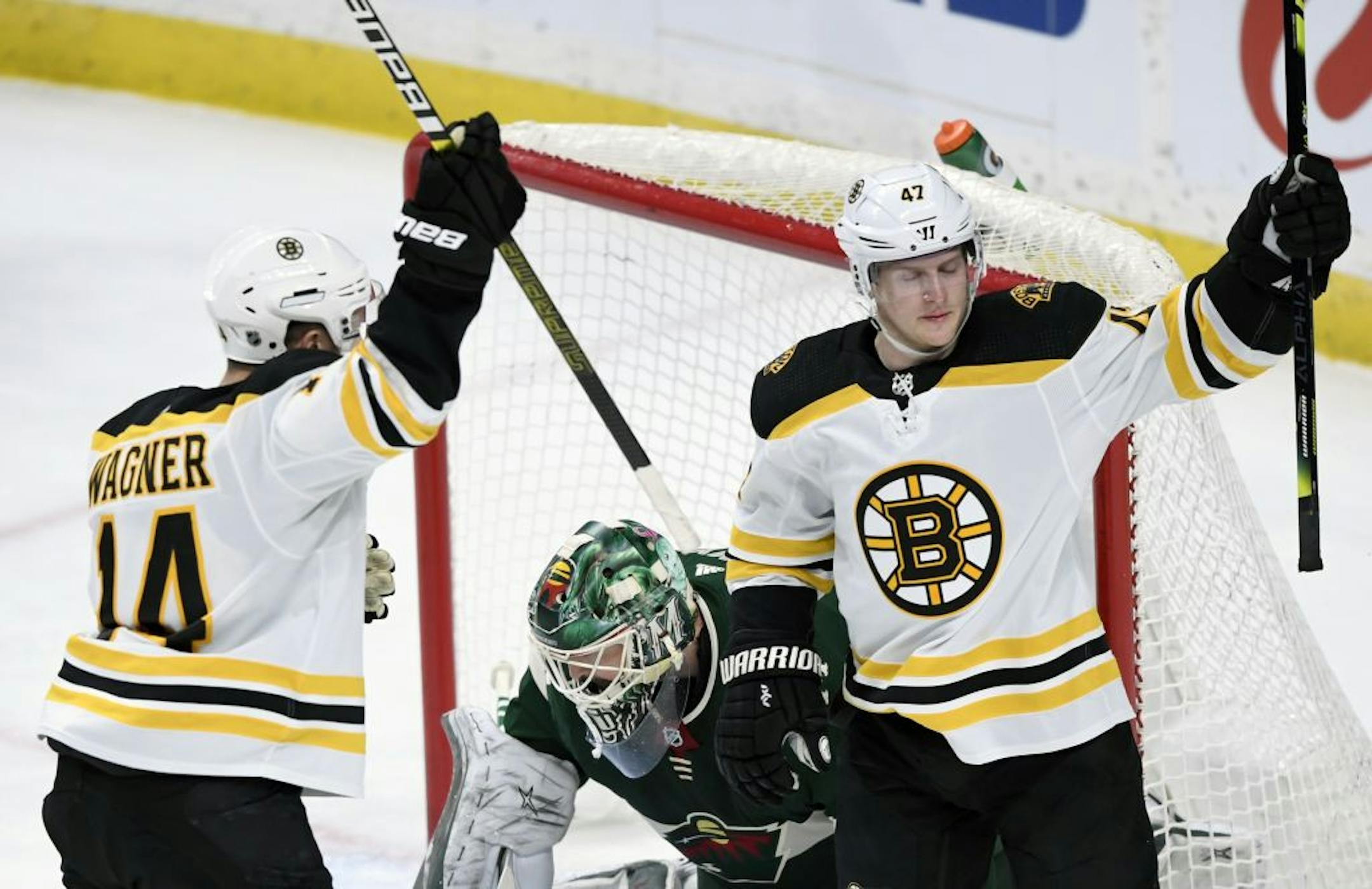 Boston Bruins' Chris Wagner (14) and Torey Krug (47) celebrate a goal by Krug as Minnesota Wild goaltender Devan Dubnyk (40) watches during the first period of an NHL hockey game Saturday, Feb. 1, 2020, in St. Paul, Minn.