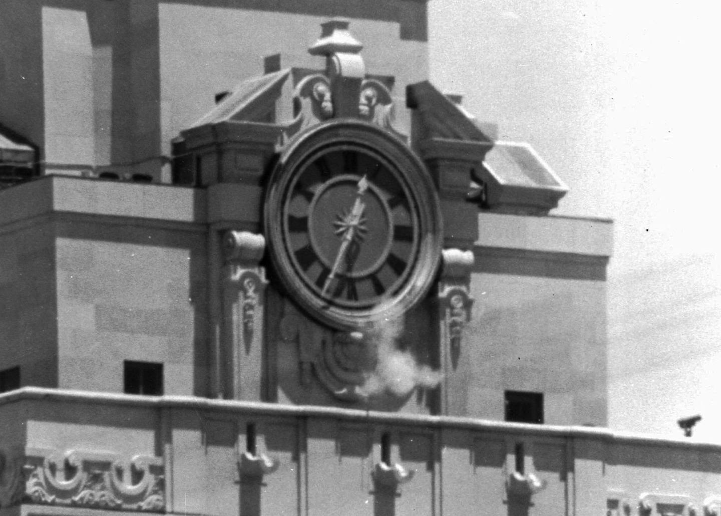 FILE - In this Aug. 1, 1966 file photo, smoke rises from the sniper's gun as he fired from the tower of the University of Texas administration building in Austin, Texas, on crowds below. Police identified the slayer of at least 16 persons as Charles J. Whitman, 24, a student at the university. Whitman's killing spree from atop the tower was so baffling to people in 1966 that then-Gov. John Connally formed a commission to study what might cause a person to erupt with such hatred and violence. Mon