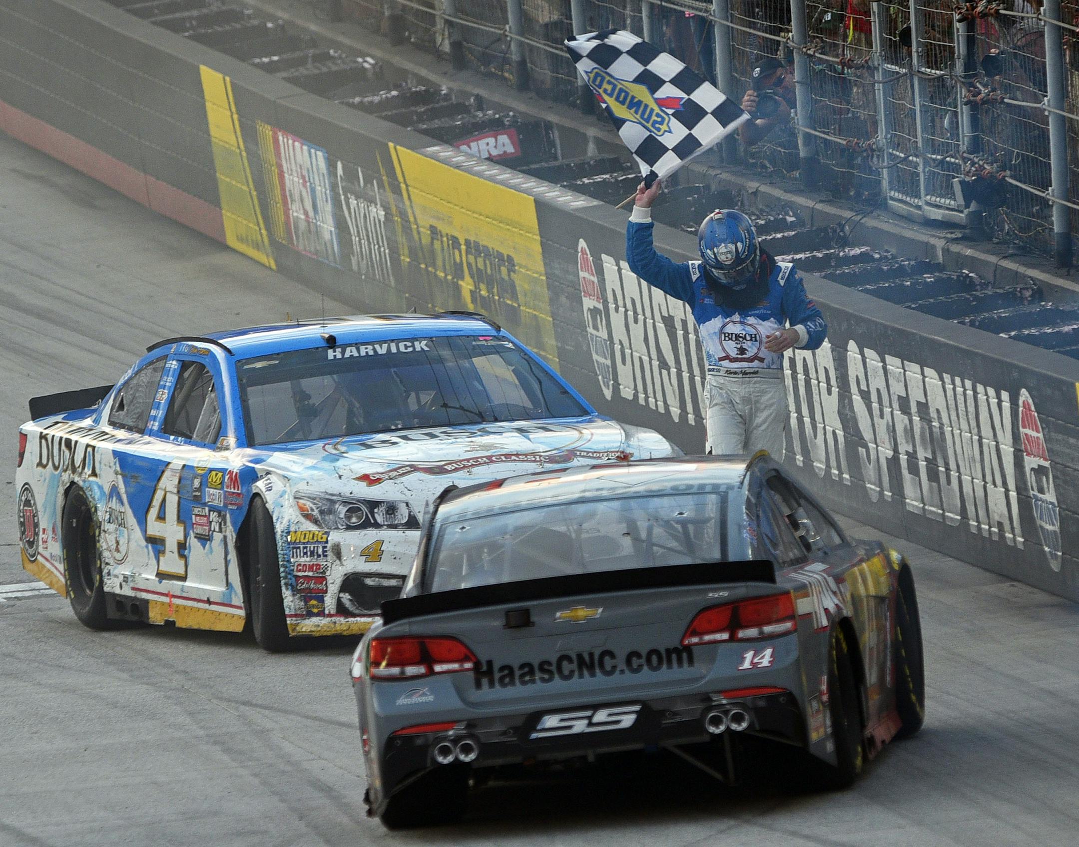 Kevin Harvick waved the checkered flag to celebrate his win after he and Stewart-Haas Racing co-owner Tony Stewart performed dual burnouts following a NASCAR Sprint Cup Series race Sunday in Bristol, Tenn.
