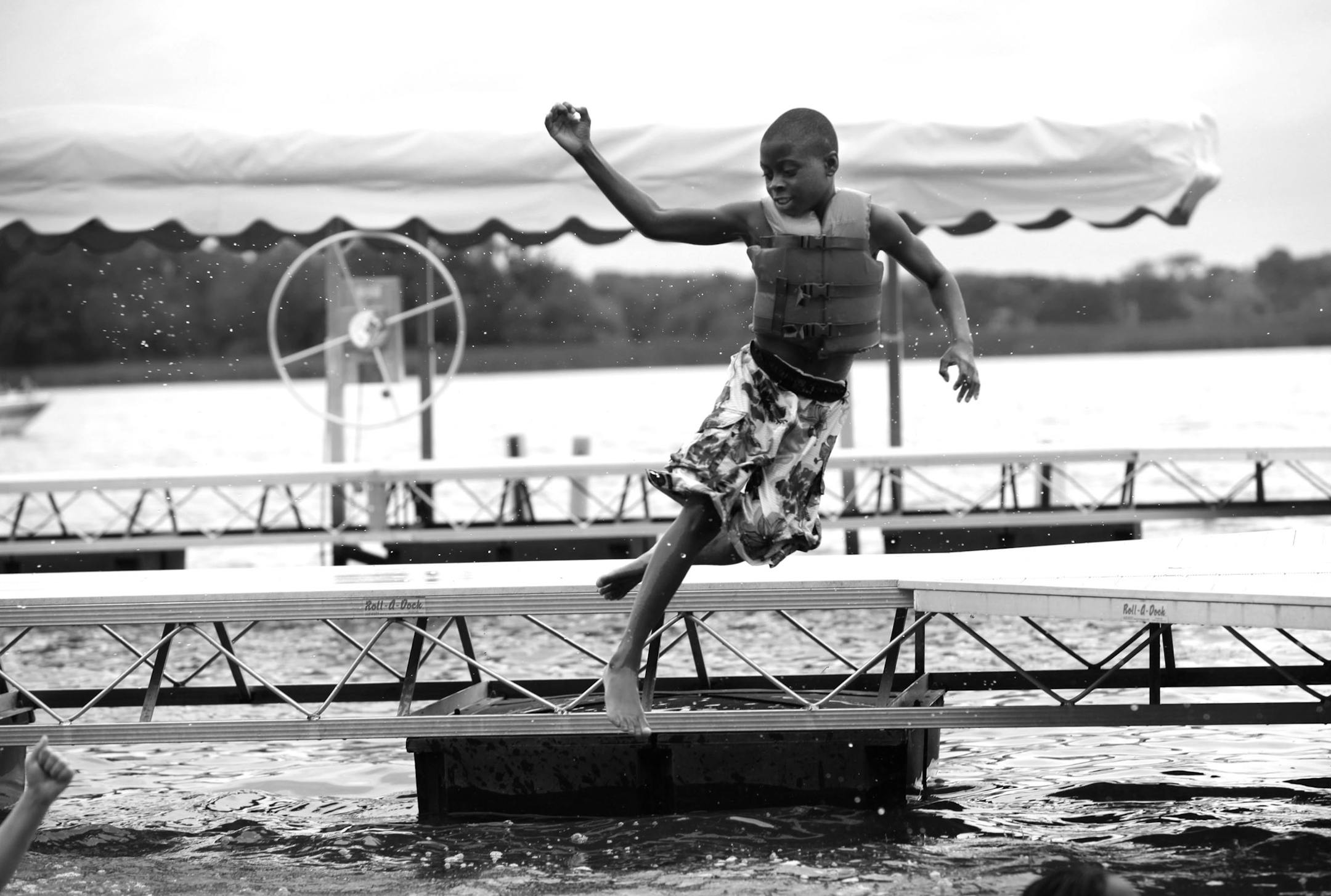 Georgio Harris leaped into the water during swimming time at YMCA Camp Ihduhapi.