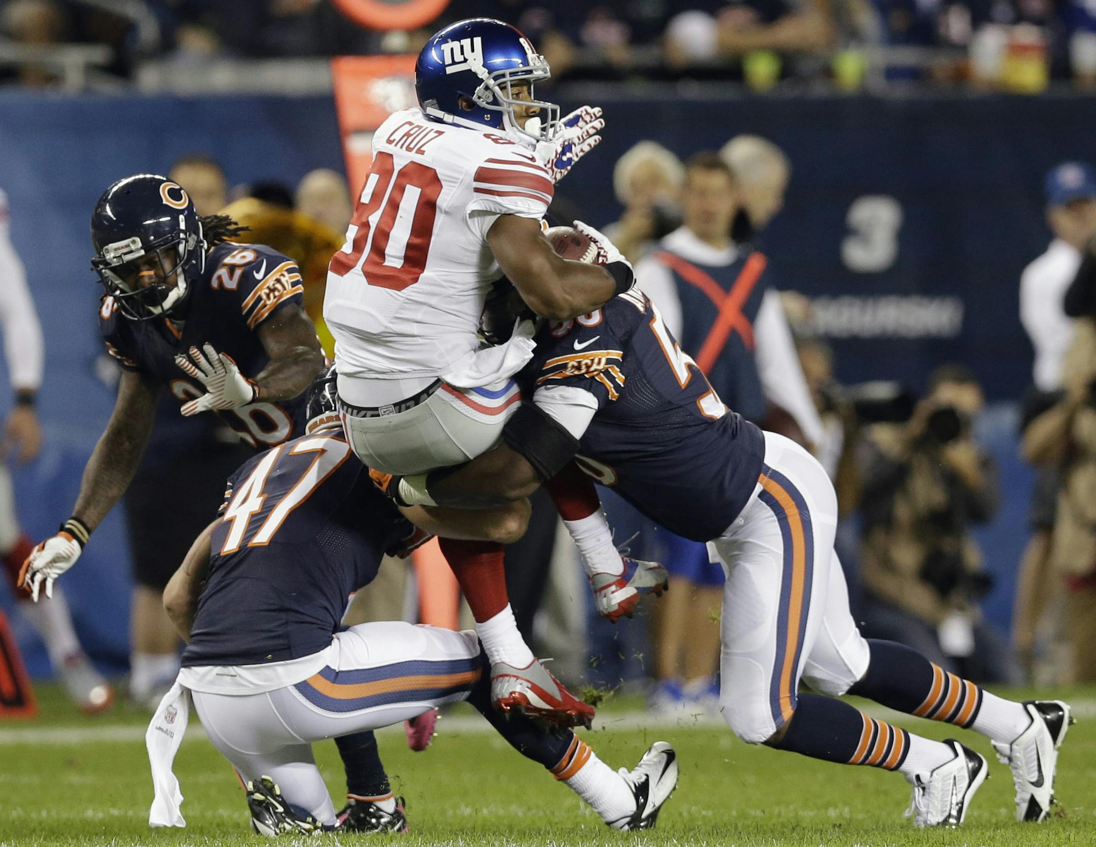 Giants wide receiver Victor Cruz (80) was tackled by Bears safety Chris Conte (47) and linebacker James Anderson on Oct. 10.