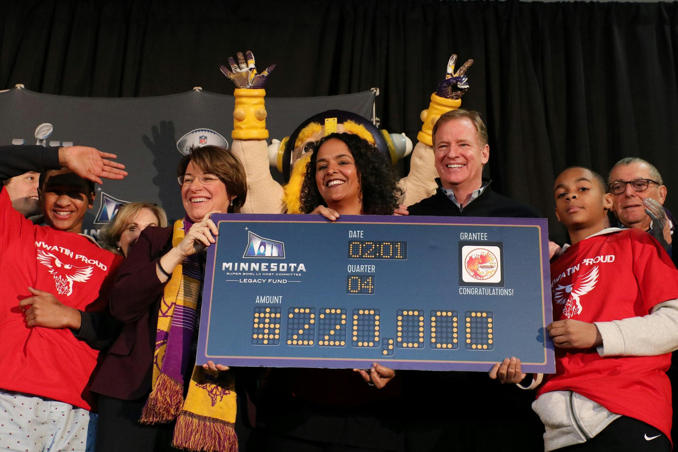 Sen. Amy Klobuchar, Anwatin Middle School principal Ellen Shulman and NFL Commissioner Roger Goodell held ceremonial check for $220 thousand awarded as a grant to the school as part of the 52 Weeks of Giving campaign.
