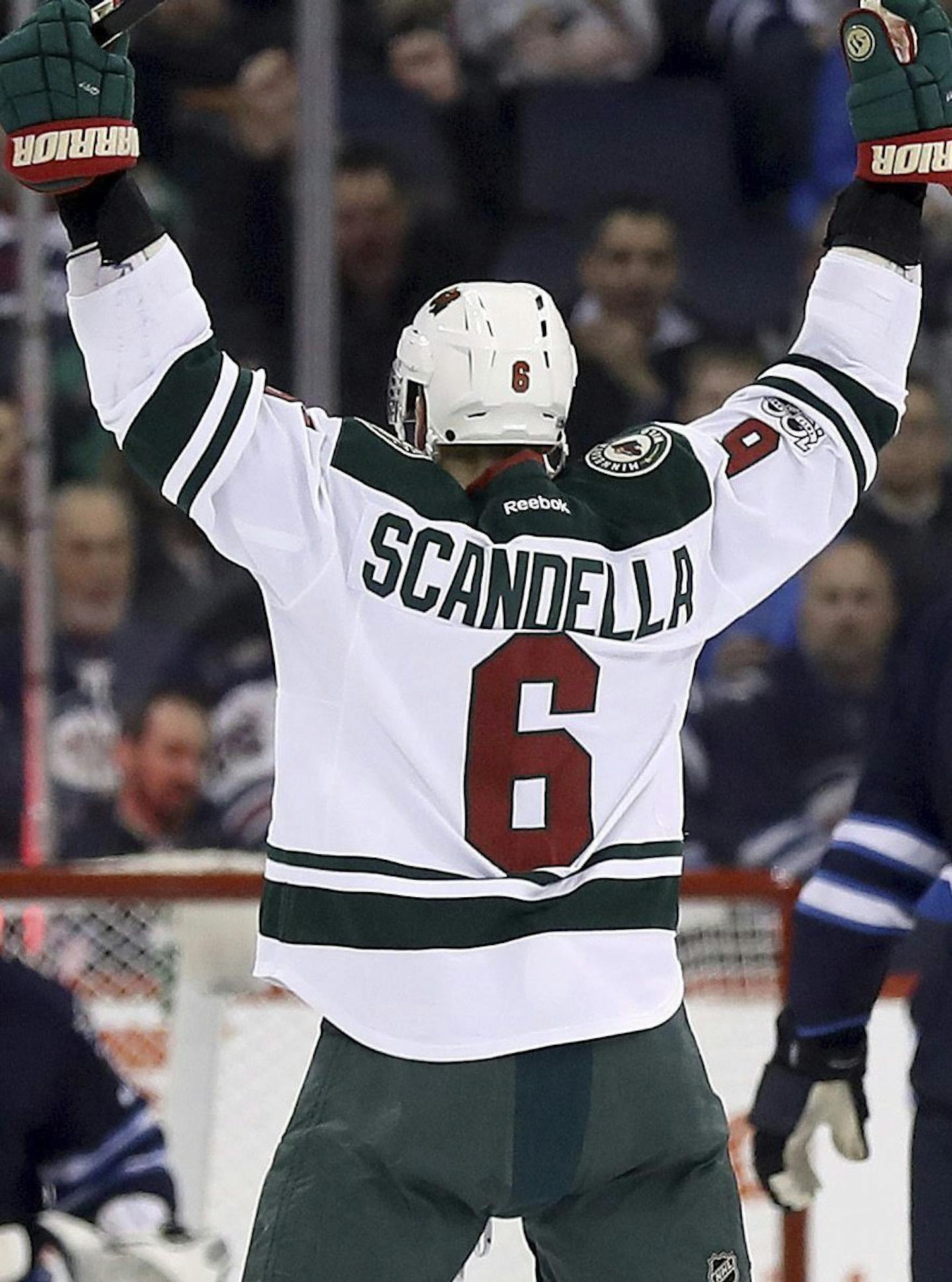 Minnesota Wild's Marco Scandella (6) celebrates after scoring on Winnipeg Jets goalie Connor Hellebuyck (37) during the second period of an NHL hockey game Tuesday, Feb. 28, 2017, in Winnipeg, Manitoba. (Trevor Hagan/The Canadian Press via AP)