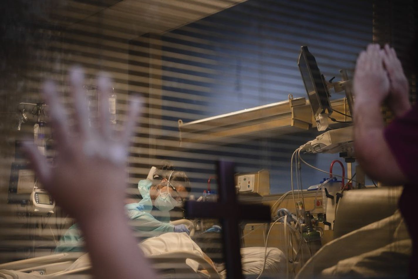 FILE -- Dominic Garcia, foreground left, prays for his mother, who had been hospitalized for three weeks with COVID-19, in Las Cruces, N.M, Nov. 17, 2020. Months into the pandemic, doctors and nurses know more than ever about how to treat COVID-19 patients. But the death toll is once again closing in on the high-water mark, set on April 15, of 2,752 deaths in a single day.