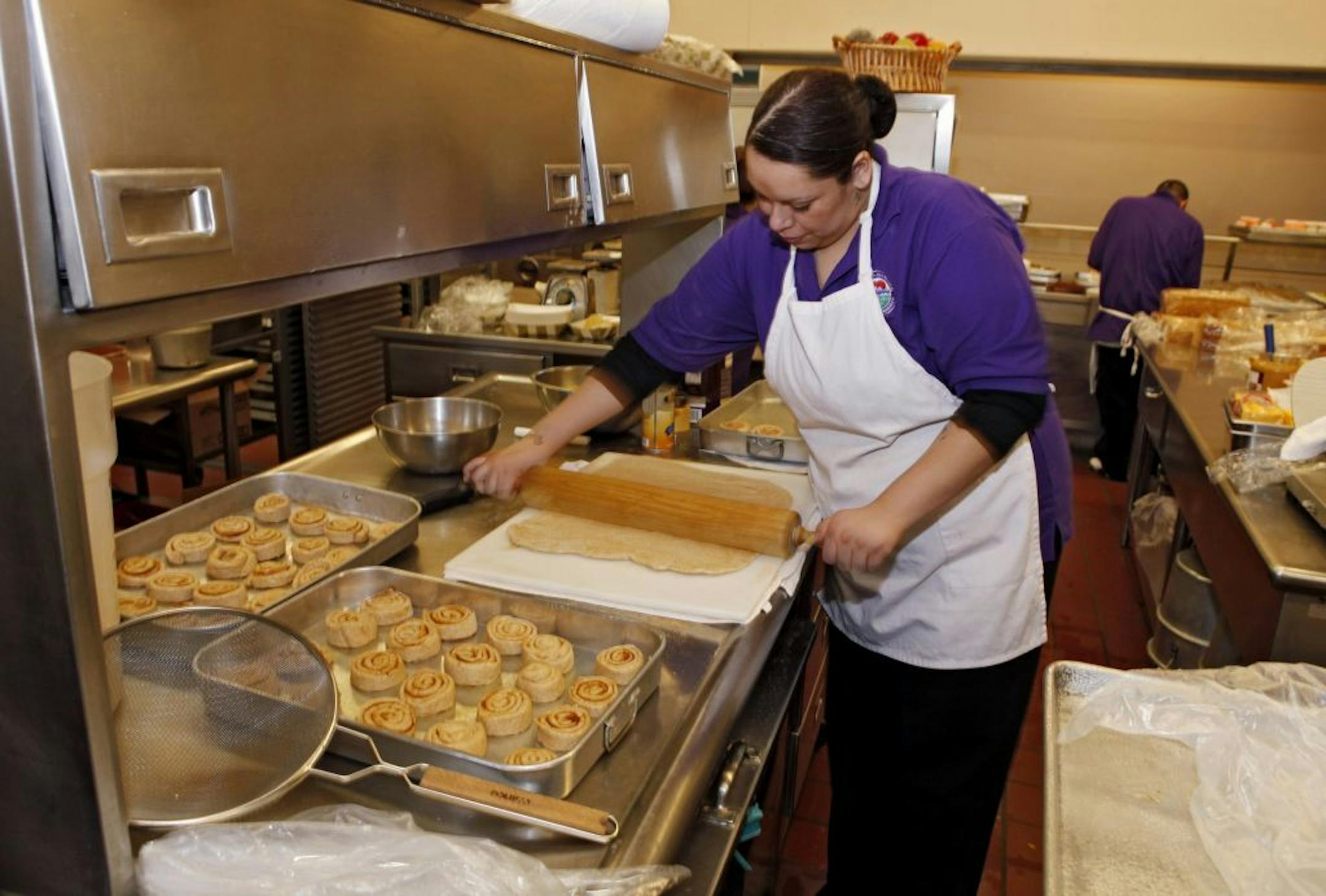 Jan. 18, 2012: Alexes Garcia makes cinnamon rolls for student's lunch in the kitchen at Kepner Middle School in Denver. The rolls are made using apple sauce instead of trans fats.