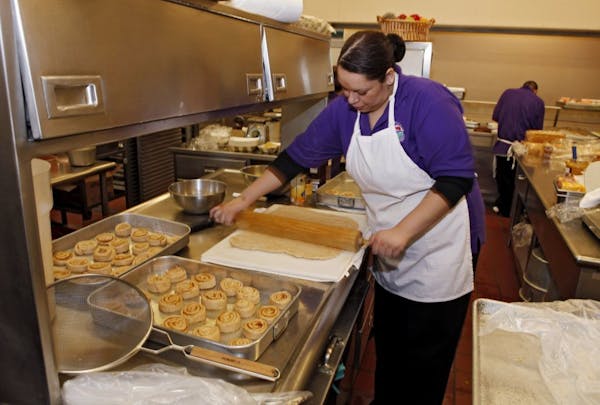 Jan. 18, 2012: Alexes Garcia makes cinnamon rolls for student's lunch in the kitchen at Kepner Middle School in Denver. The rolls are made using apple