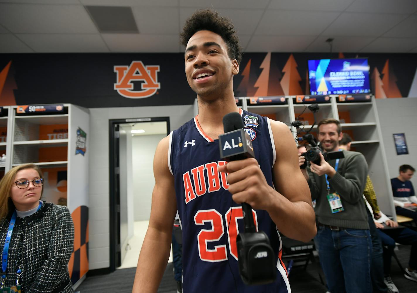 Auburn forward Myles Parker holds a media microphone during media availability in the team locker room.