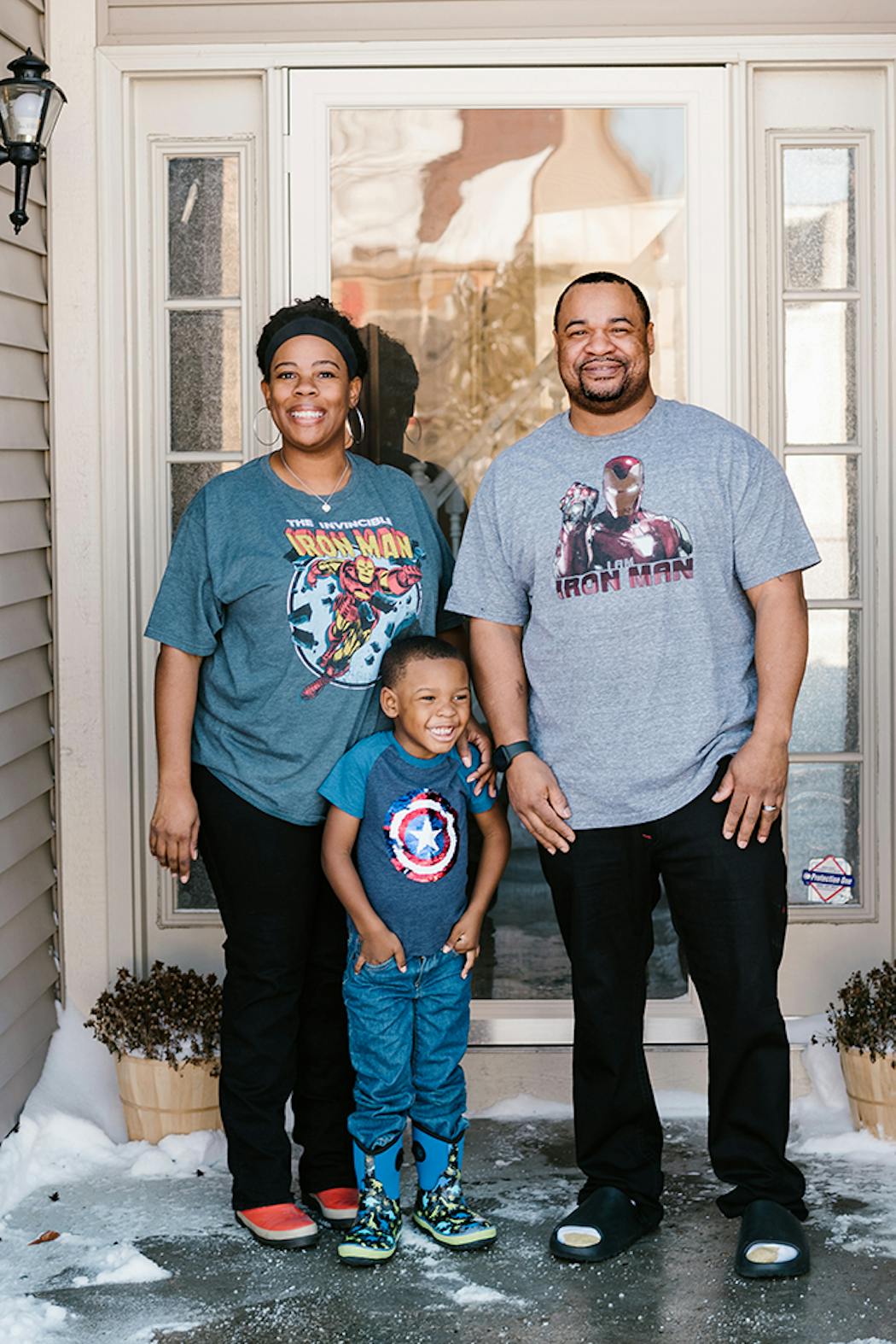 Rineeka and Steven Sheppard, who added a concession stand to their basement theater, outside their home with their son, Tristan, in Indianapolis.