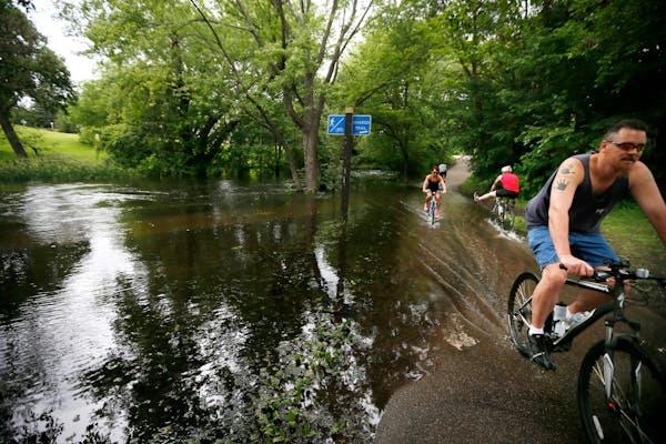 High water flooded the walking and bike paths along Minnehaha Creek on Sunday in Minneapolis.
