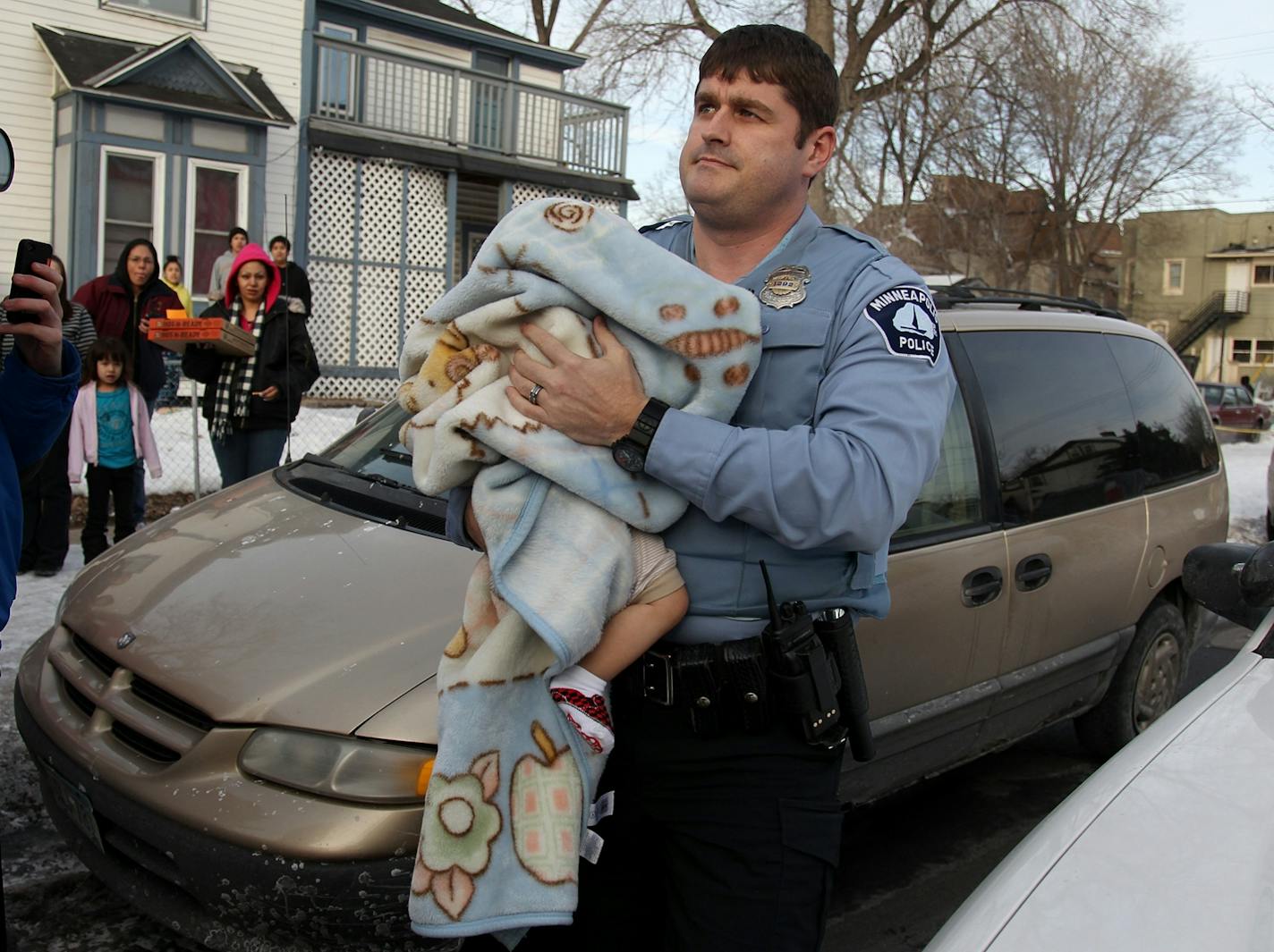 Police carried 8-month old Carlos Orozco to an ambulance so that he may be reunited with his mother Vicky Orozco near the corner of E. 22nd Street and Portland Avenue South, Wednesday, February 20, 2013 in Minneapolis, MN. (The multiplex is in the background) (ELIZABETH FLORES/STAR TRIBUNE) ELIZABETH FLORES � eflores@startribune.com