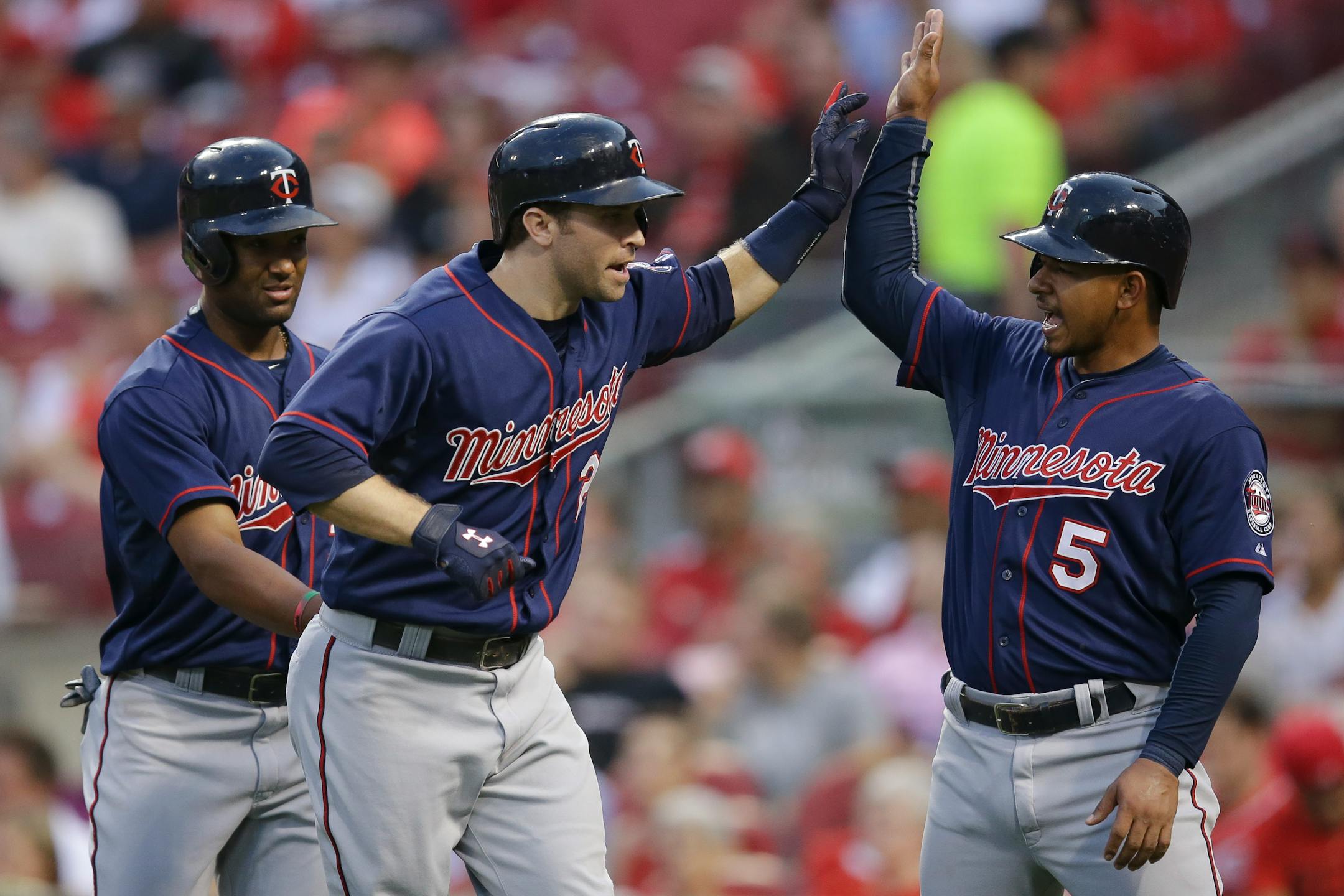 The Twins' Brian Dozier, center, celebrated with Eduardo Escobar (5) and Danny Santana, left, after hitting a three-run homer in the fourth inning Monday at Cincinnati.