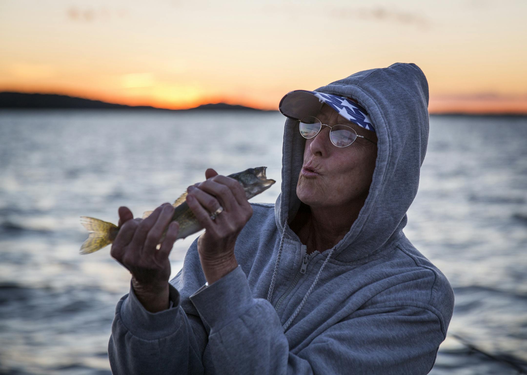 Frankie Giarrusso, East Bethel during the summer and Texas during the winter, pretends to kiss her walleye catch during a fishing expedition with Twin Pines Resort on Mille Lacs Lake Monday, August 3, 2015. ] LEILA NAVIDI leila.navidi@startribune.com /
