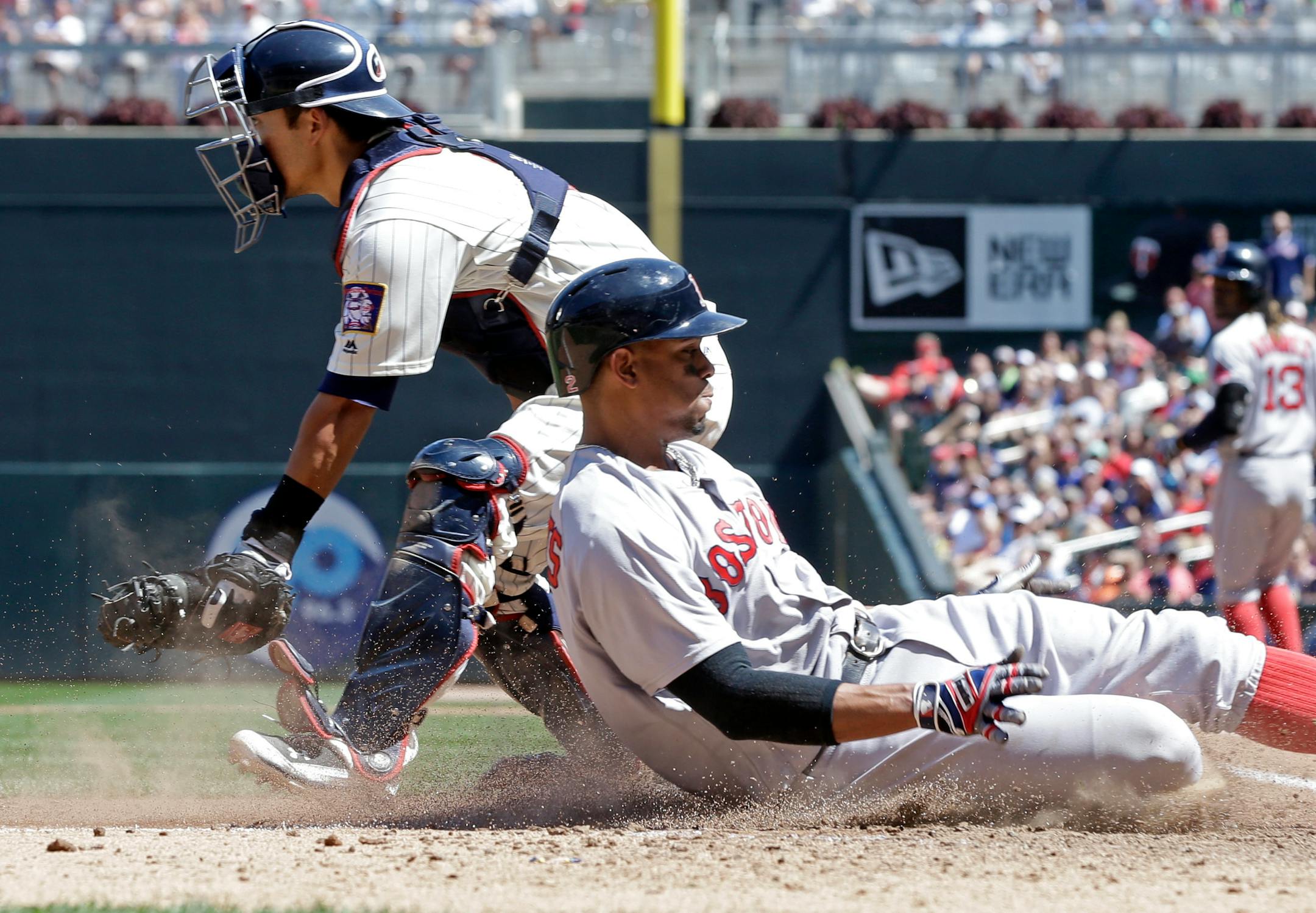 Boston Red Sox's Xander Bogaerts, right, scores from third on a go-ahead run past Minnesota Twins catcher Kurt Suzuki on a sacrifice fly by Hanley Ramirez in the sixth inning of a baseball game Saturday, June 11, 2016, in Minneapolis. (AP Photo/Jim Mone)