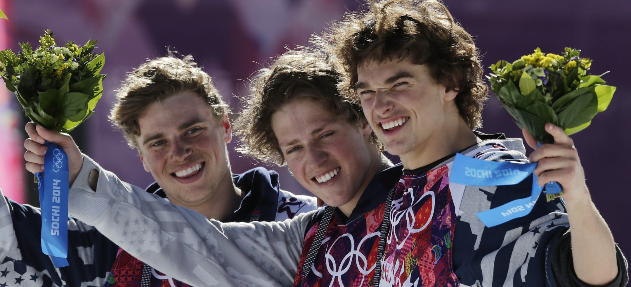 Men's ski slopestyle gold medal winner Joss Christensen of the United States, center, celebrates on the podium with his teammates Gus Kenworthy, left, silver, and Nicholas Goepper, bronze, right, during a flower ceremony at the Rosa Khutor Extreme Park, at the 2014 Winter Olympics, Thursday, Feb. 13, 2014, in Krasnaya Polyana, Russia. (AP Photo/Andy Wong)