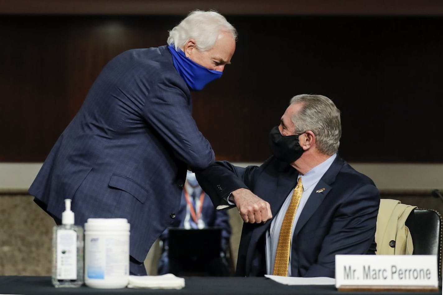 Sen. John Cornyn, R-Texas, greets Marc Perrone, international president of the United Food and Commercial Workers International Union with an elbow bump, prior to the start of a Senate Judiciary Committee hearing examining liability during the coronavirus disease (COVID-19) outbreak, Tuesday, May 12, 2020 on Capitol Hill in Washington.