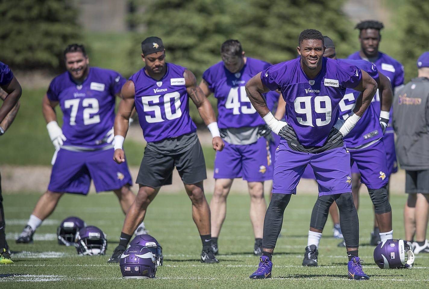 Defensive end Danielle Hunter, right, stretched with other defensive players before going onto the field during a minicamp at the TCO Performance Center