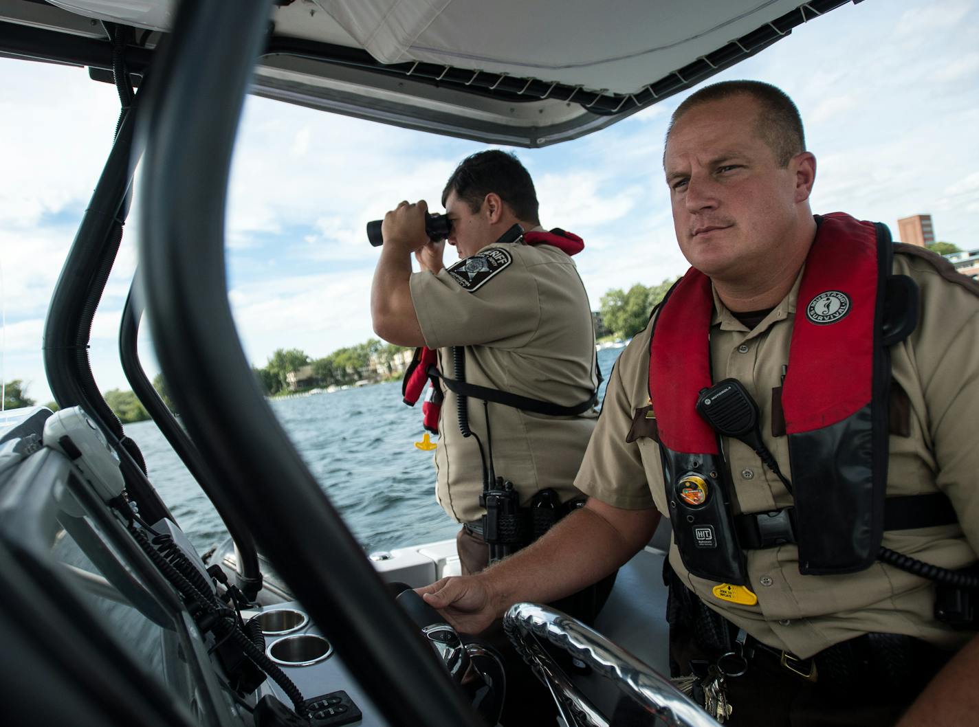 Hennepin County Sheriff's Office special deputy Amir Gharbi, left, used binoculars to look for possible boater infractions on the water as deputy Jeremy Gunia steered their boat during a patrol of Lake Minnetonka Saturday afternoon. ] (AARON LAVINSKY/STAR TRIBUNE) aaron.lavinsky@startribune.com We do a ride along with the Hennepin County Sheriff's Office Water Patrol, one of the largest such patrols in the country, as deputies patrol Lake Minnetonka on the final big boating weekend of the season