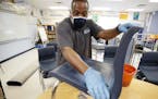 Des Moines Public Schools custodian Tracy Harris cleans a chair in a classroom at Brubaker Elementary School, Wednesday, July 8, 2020, in Des Moines, 