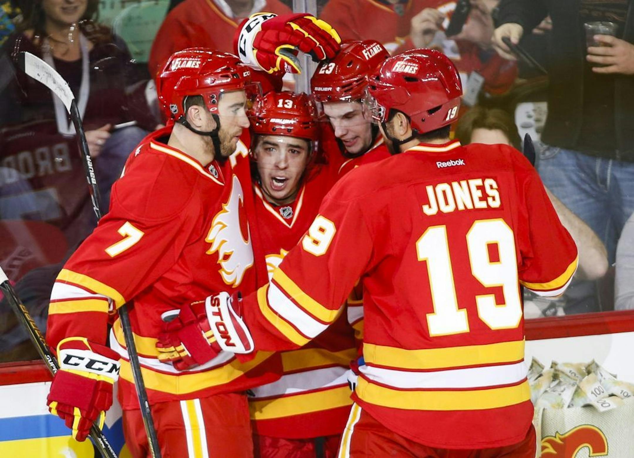 Calgary Flames' Johnny Gaudreau, second from left, celebrates his goal with teammates T. J. Brodie, (7) Sean Monahan and David Jones (19) during the second period of an NHL hockey game against the Ottawa Senators on Saturday, Feb. 27, 2016, in Calgary, Alberta.