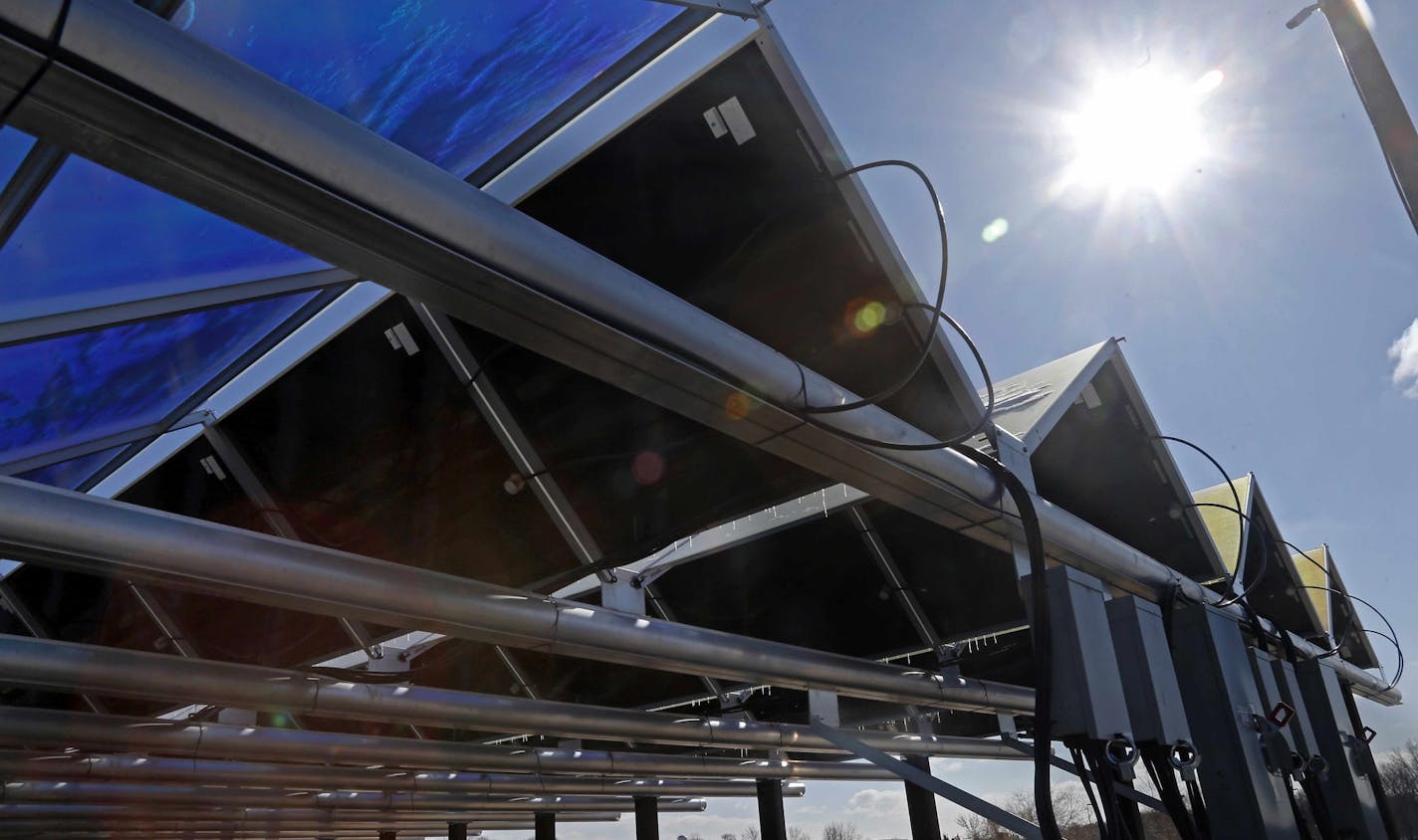 In this Feb. 26, 2015 photo, the sun shines down on solar panels that are part of the Wright-Hennepin Cooperative Electric Association's community gardens are shown in Rockford, Minn. Community solar gardens are a new concept in renewable energy, allowing customers who cannot put up solar panels to buy into the green energy boom anyway. (AP Photo/Jim Mone) ORG XMIT: MP102