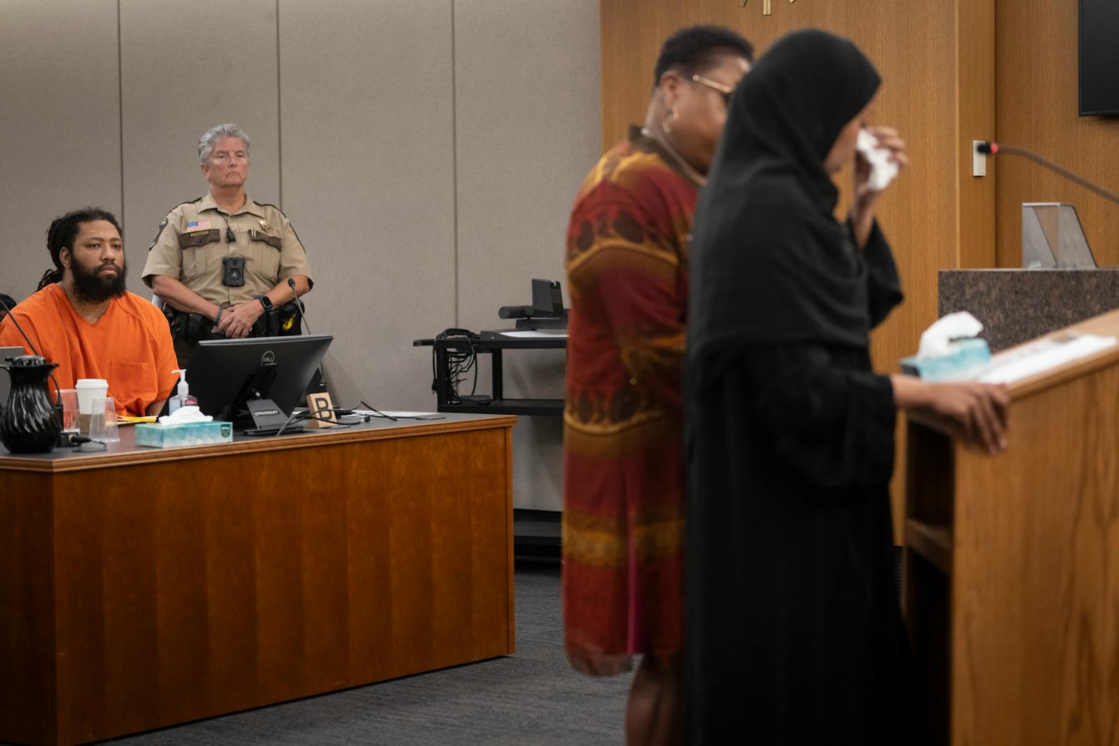 Derrick Thompson, at left, listens as Sundus Odhowa, Siham Adam’s older sister, gives an impact statement during sentencing at the Hennepin County Government Center on Thursday.