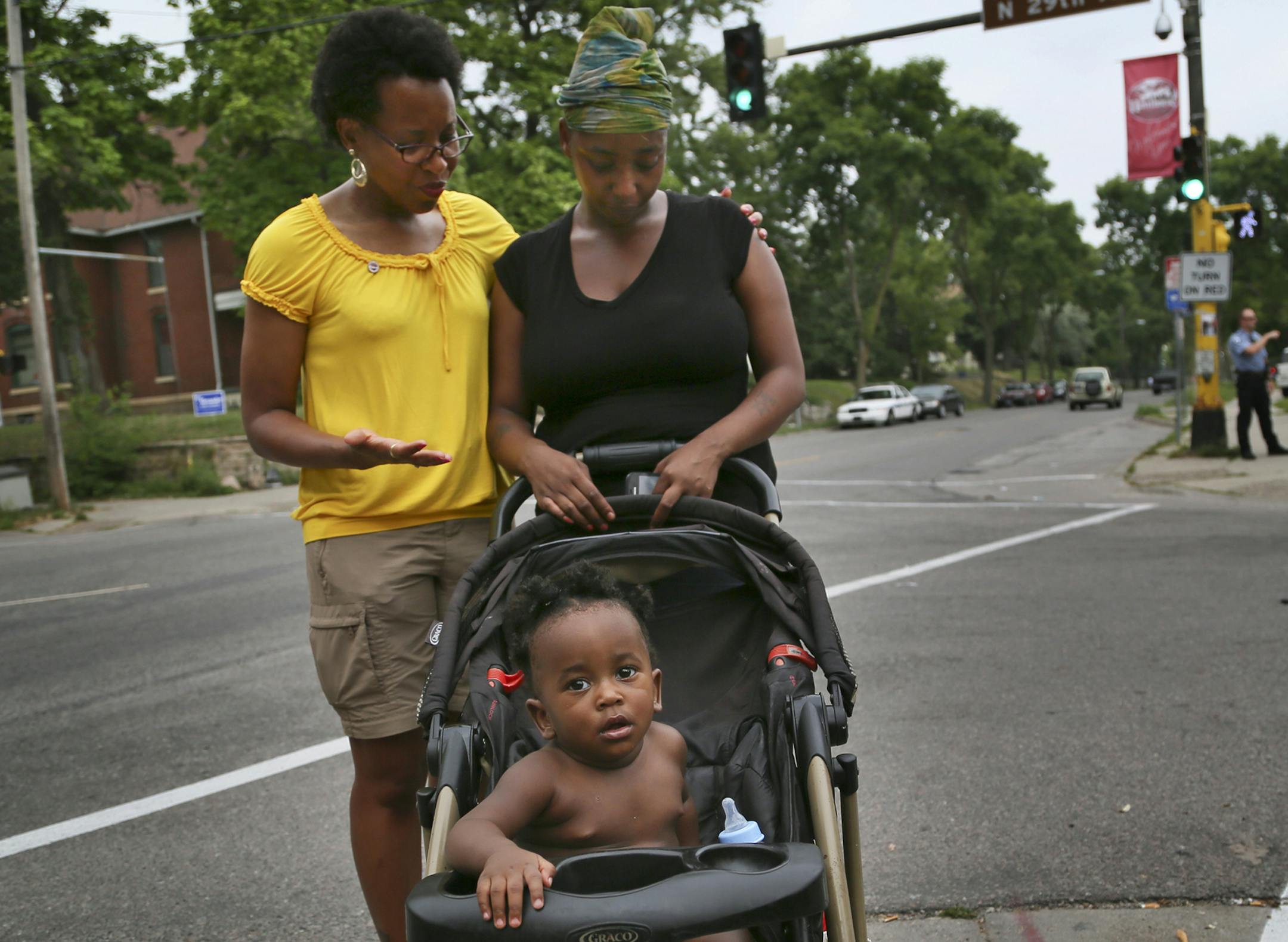 Having witnessed the shooting of her relatives yesterday, Teona Franklin is prayed over by urban minister Melanie Leehy, left, about a half a block from where the shooting took place Tuesday and photographed Wednesday, Aug. 21, 2013, in Minneapolis, MN. At one point, Franklin saw a baby hit by the gunfire and first believed it was her son Lamont, 11 months, in the stroller that had been shot. Franklin was headed to the corner of N. 29 and Lyndale Ave. for the vigil.](DAVID JOLES/STARTRIBUNE) djo