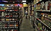 Veronica Perkins, 21, carries cans of beer while restocking the shelves at Team Liquor where she works Wednesday, Jan. 28, 2014. Perkins finishes work