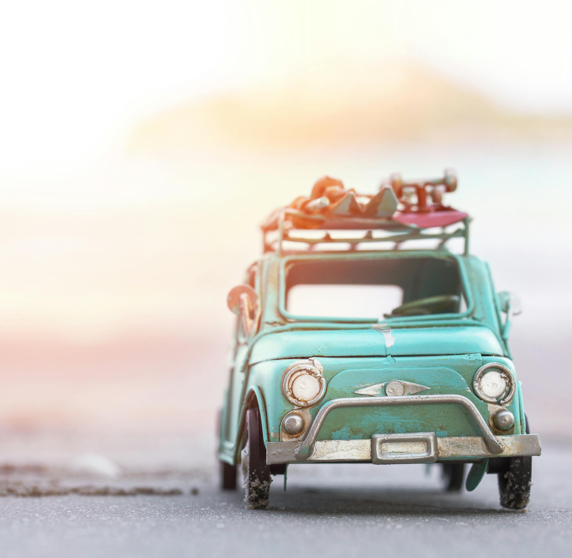 Miniature tin car closeup at summer beach scene