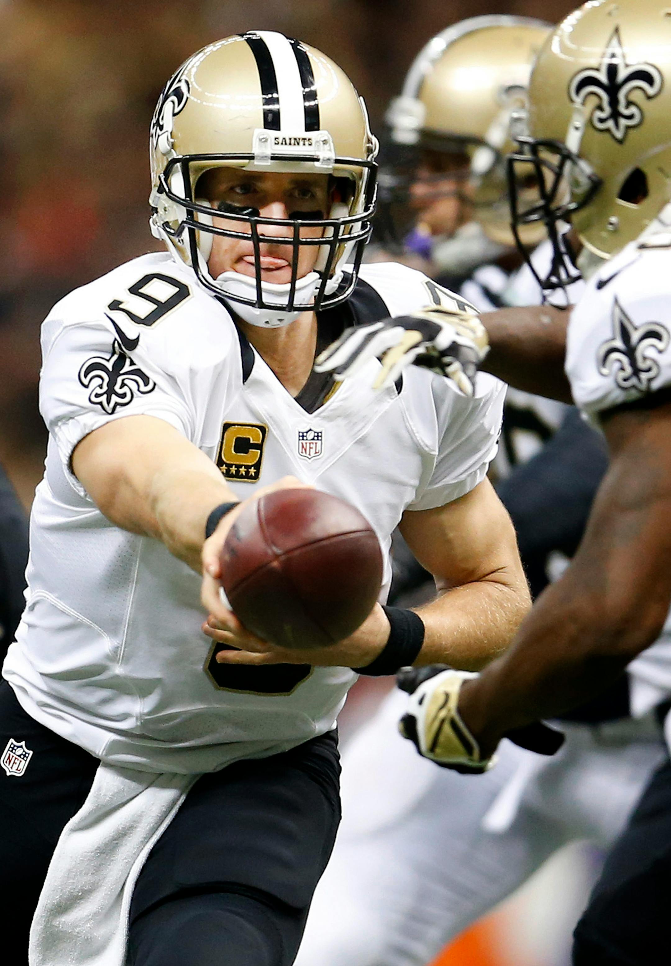 Saints quarterback Drew Brees (9) handed the ball off in the second quarter.