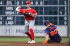 Angels shortstop Zach Neto, left, attempts a double play after retiring the Astros' Kyle Tucker at second base during the seventh inning Monday in Hou